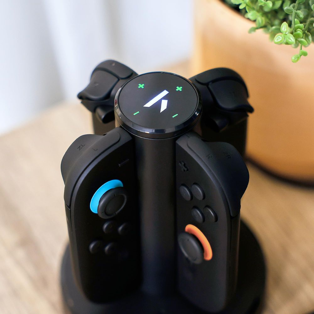 Ein schwarzer Controller-Ständer mit vier Controllern und einem runden Display oben.