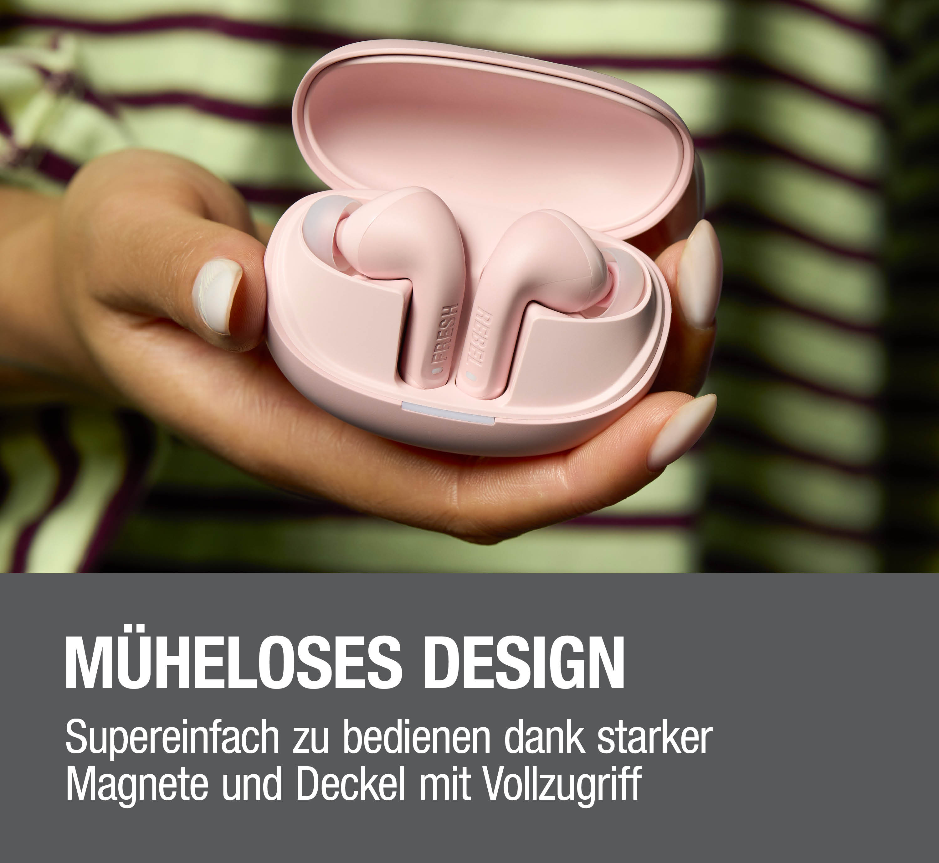 Rosa kabellose Ohrhörer in offener Hülle, in der Hand gehalten. Text: Müheloses Design.