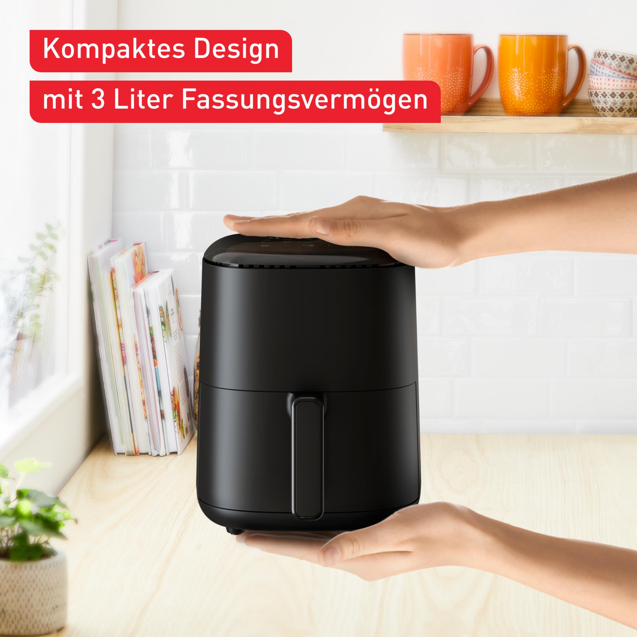 Schwarzer Heißluftfritteusen auf Holztisch, Hände bedecken Ober- und Unterseite.