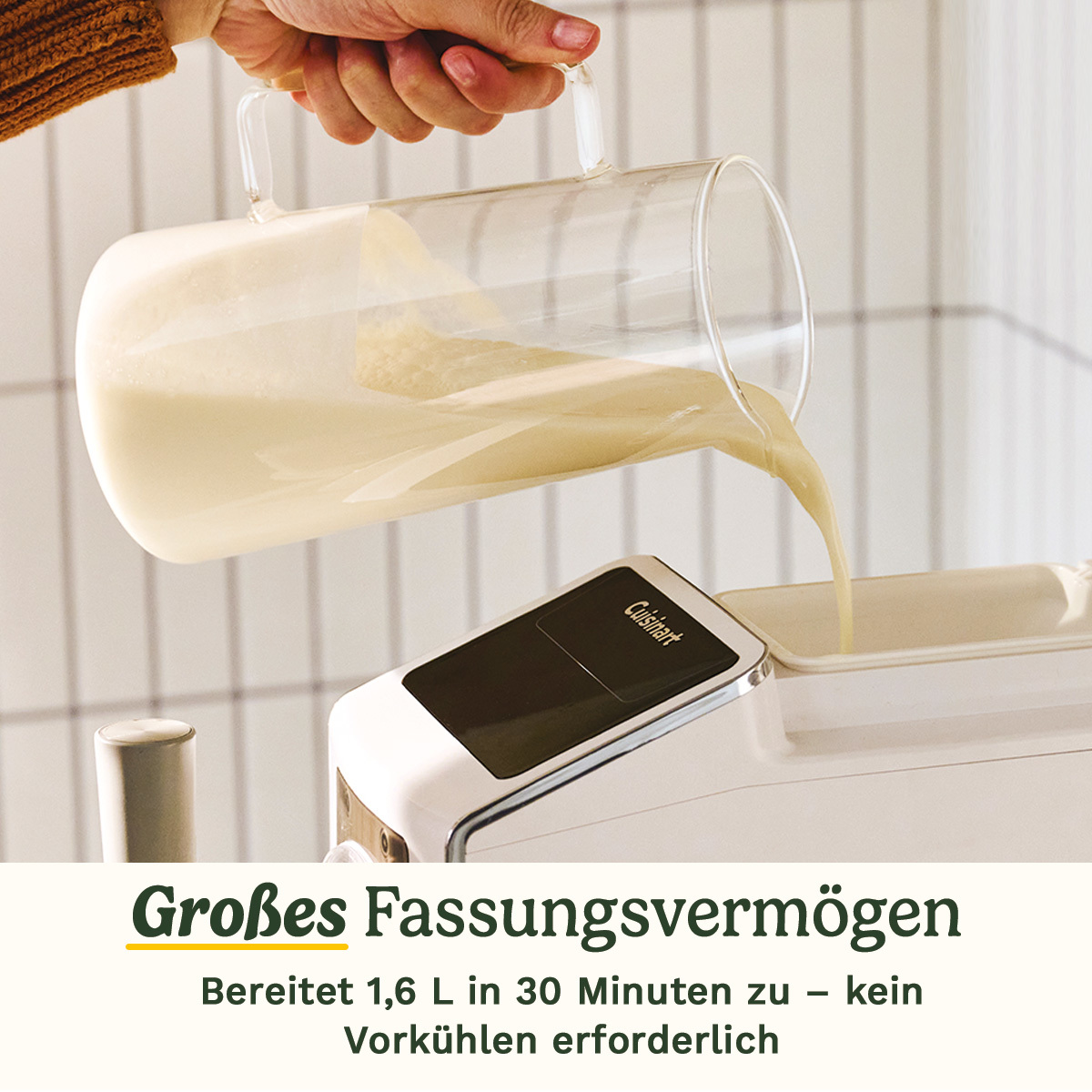 Eine Hand gießt cremige Flüssigkeit aus einer Glaskaraffe in eine Eismaschine.