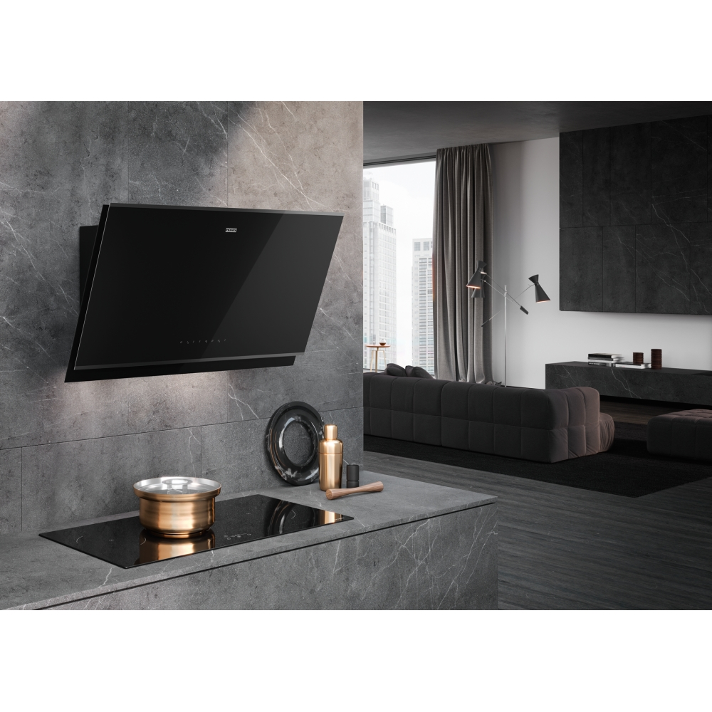 Cucina moderna con cappa nera, piano cottura e zona salotto.