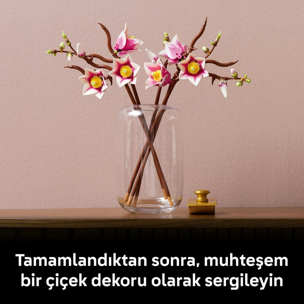 Ahşap bir masa üzerinde pembe ve beyaz çiçekli cam vazo.