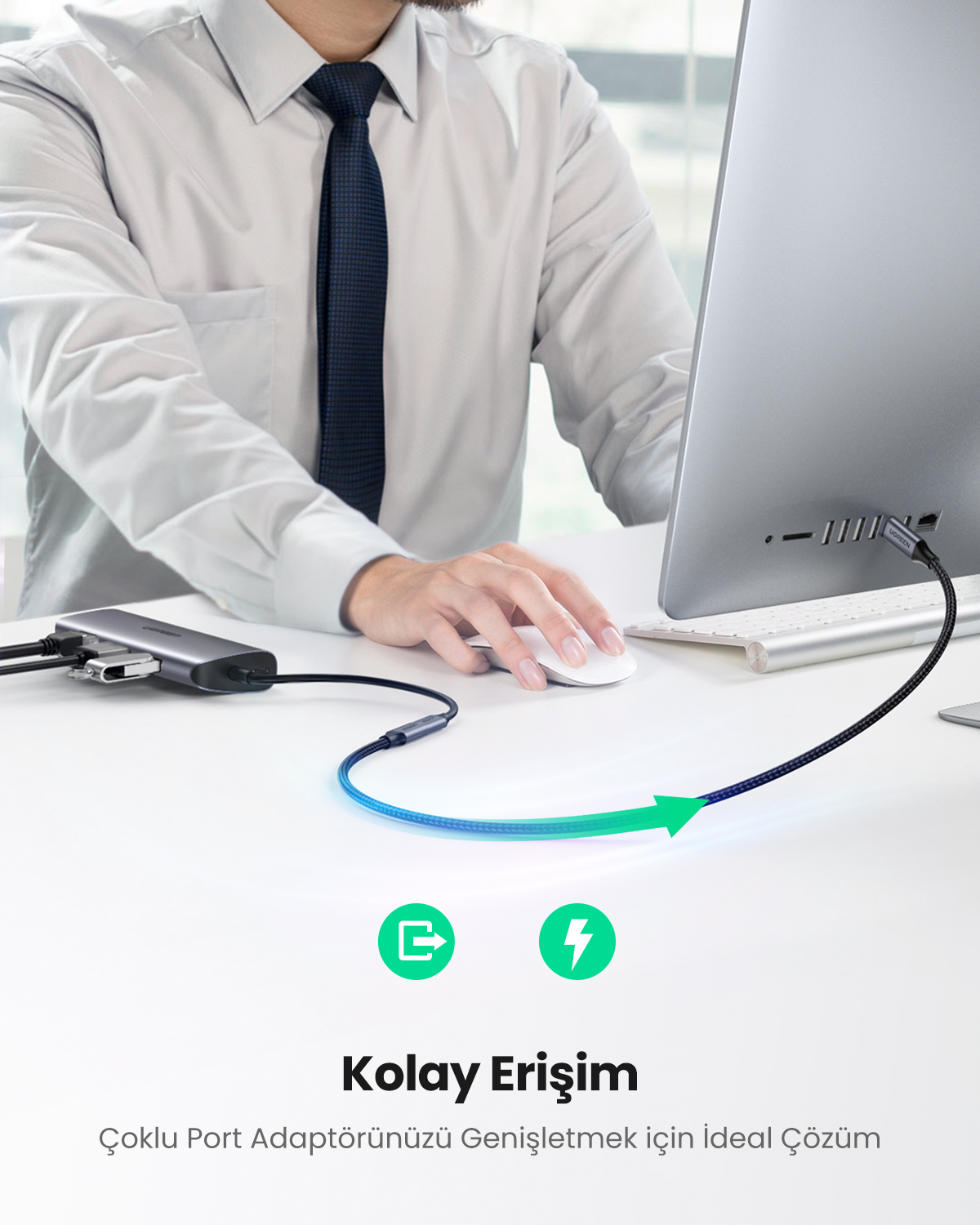 Adam masasında USB-C hub'ı PC'ye bağlıyor. Ok şarj olduğunu gösteriyor.
