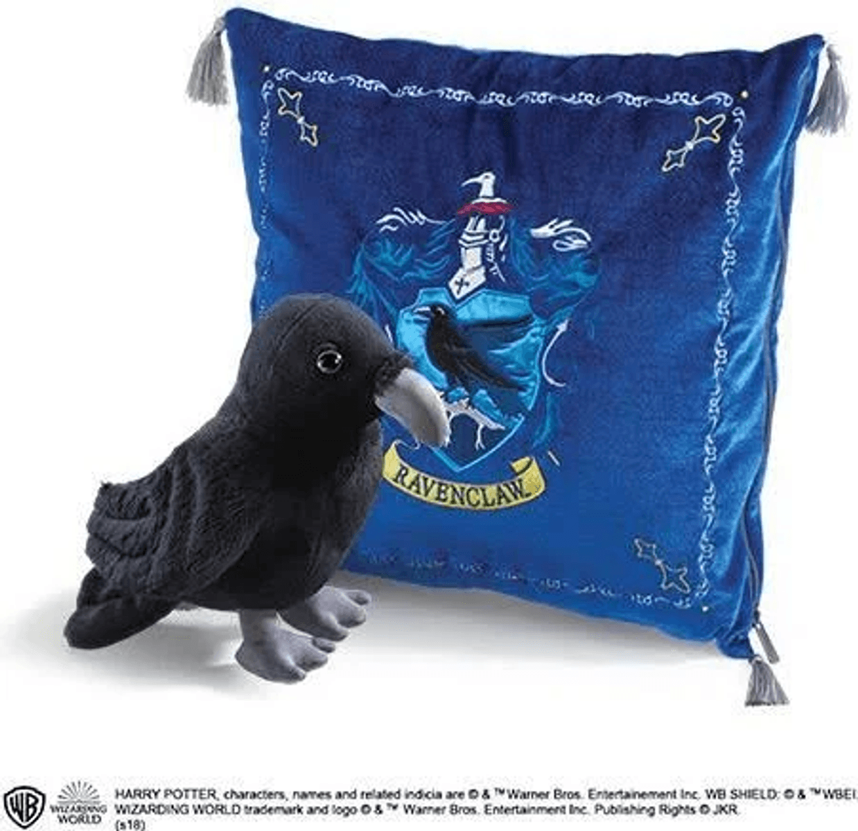 Un peluche de cuervo junto a un cojín azul con el escudo de Ravenclaw.