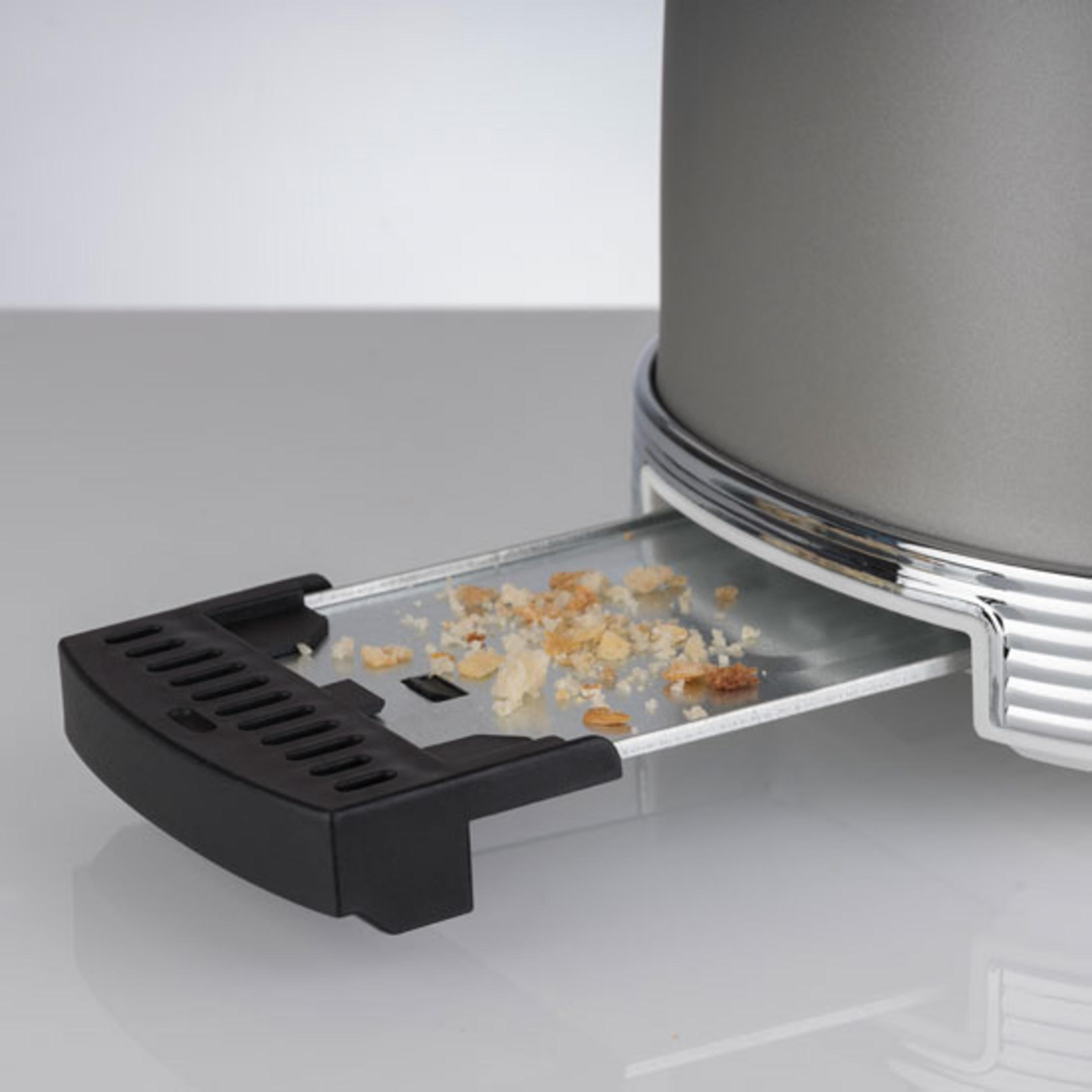 Krümel auf dem ausziehbaren Fach eines grauen Toasters.