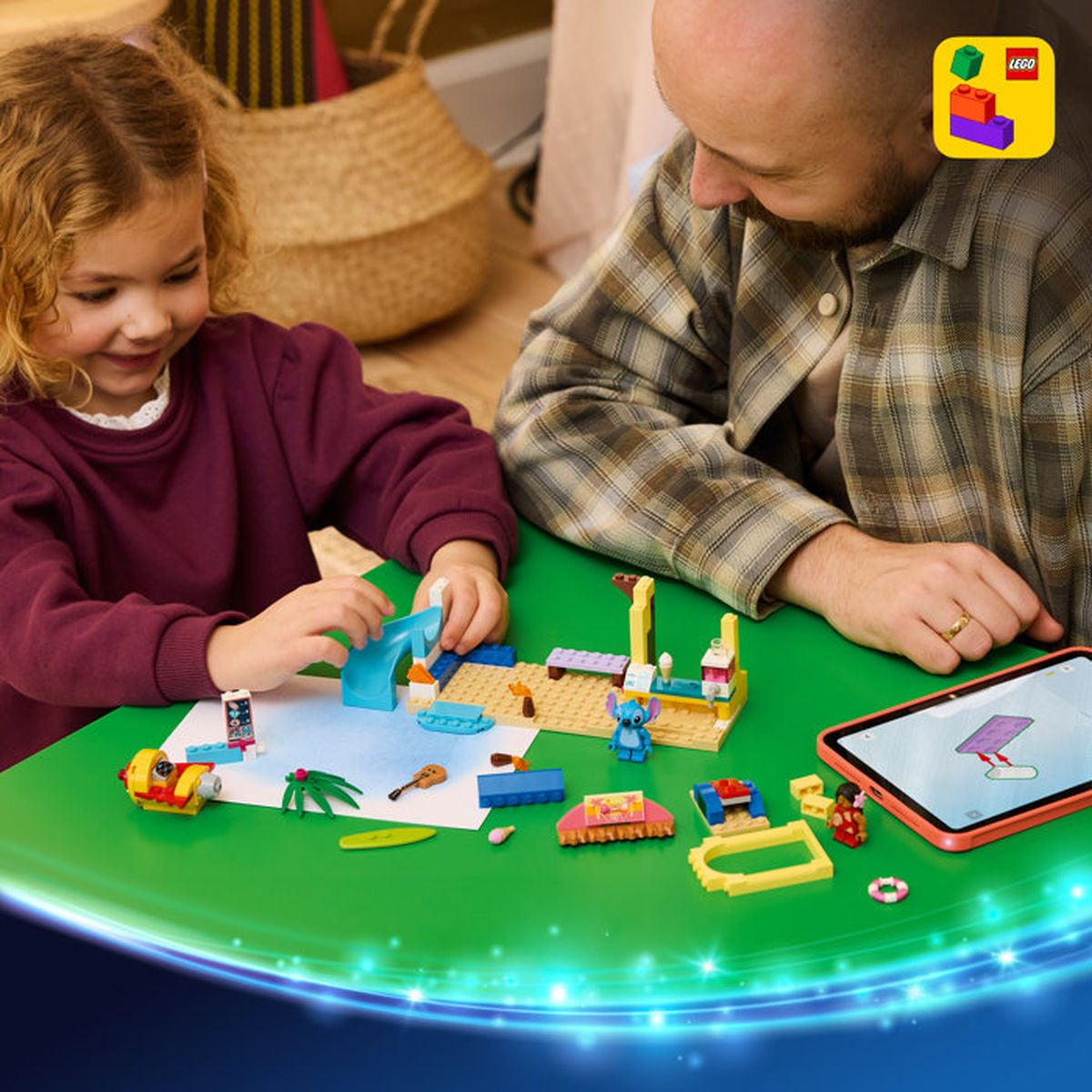 Padre e figlia costruiscono con LEGO a un tavolo. Un tablet mostra le istruzioni.
