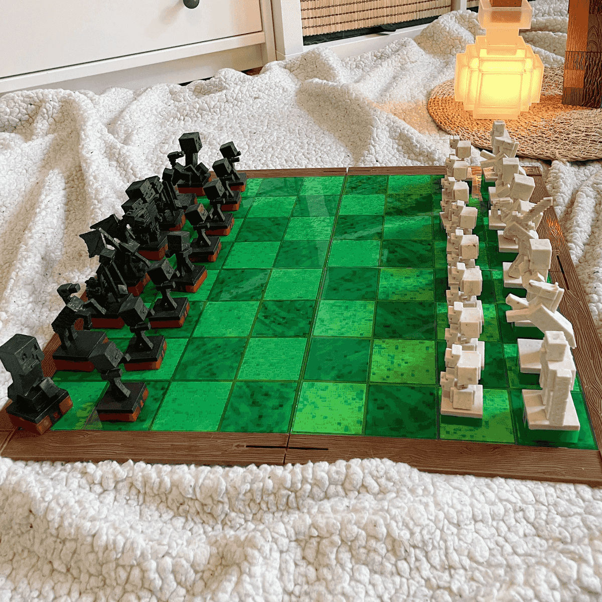 Un juego de ajedrez temático de Minecraft con figuras blancas y negras en un tablero verde.