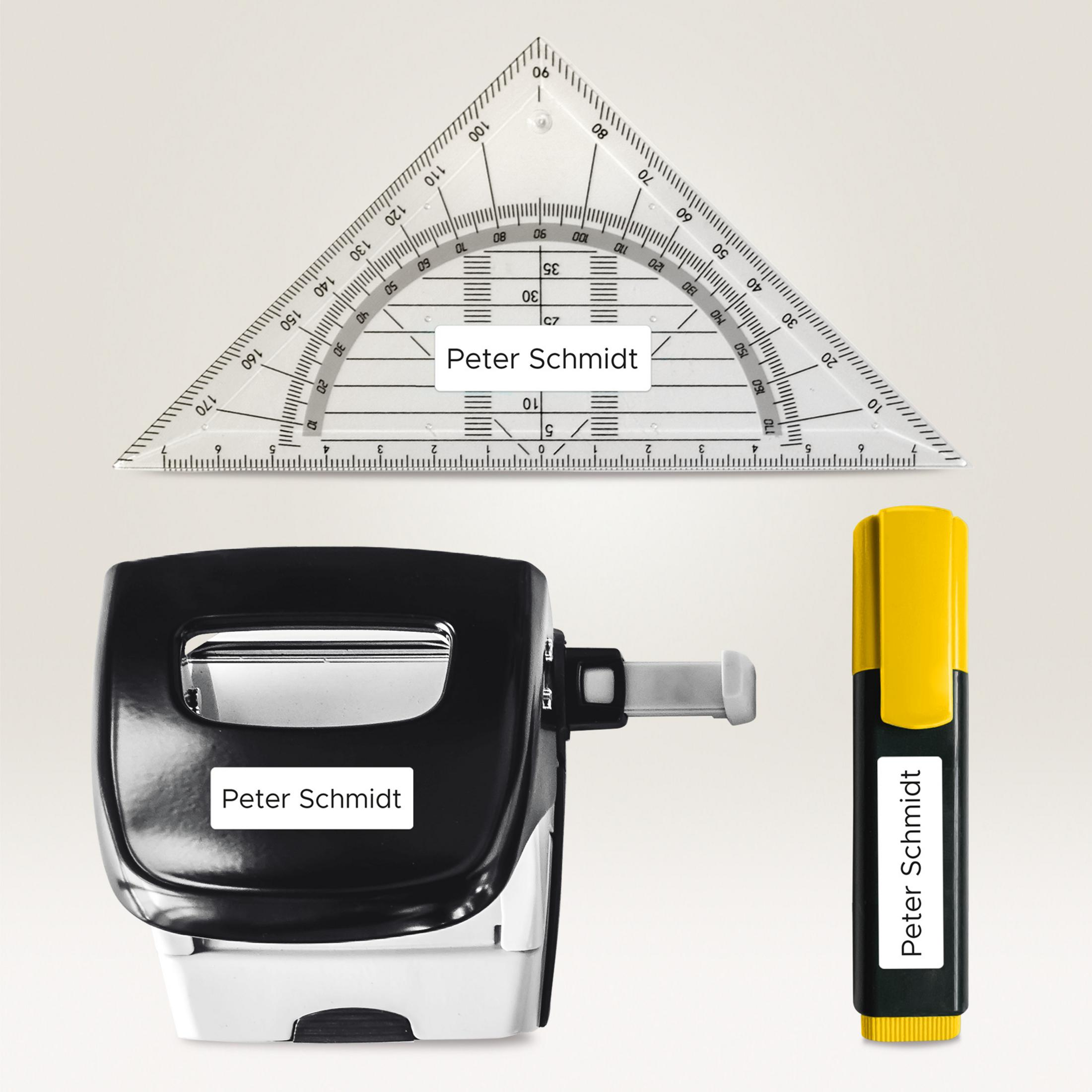 Ein Dreiecklineal, ein schwarzer Stempel und ein gelber Textmarker, alle mit Namen.