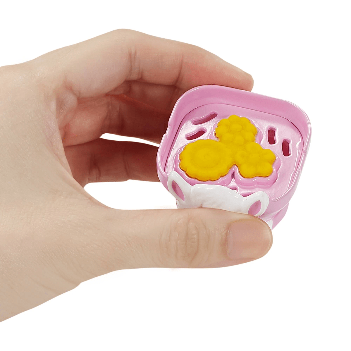 Eine Hand hält ein rosa Spielzeug mit einem gelben Mickey-Maus-förmigen Objekt.