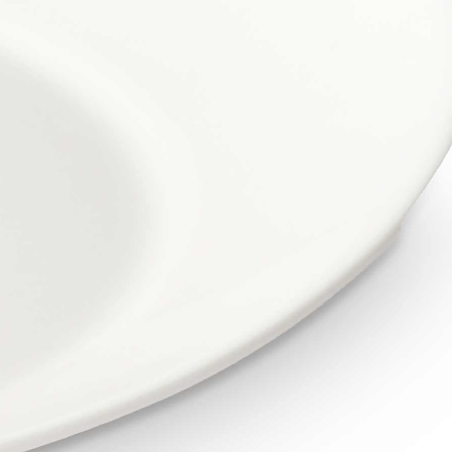 Una vista ravvicinata di un piatto rotondo bianco con un'ombra sul lato.
