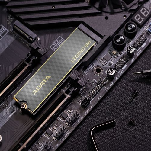 ADATA Legend 860 SSD op een computer moederbord, met schroeven en gereedschap in de buurt.