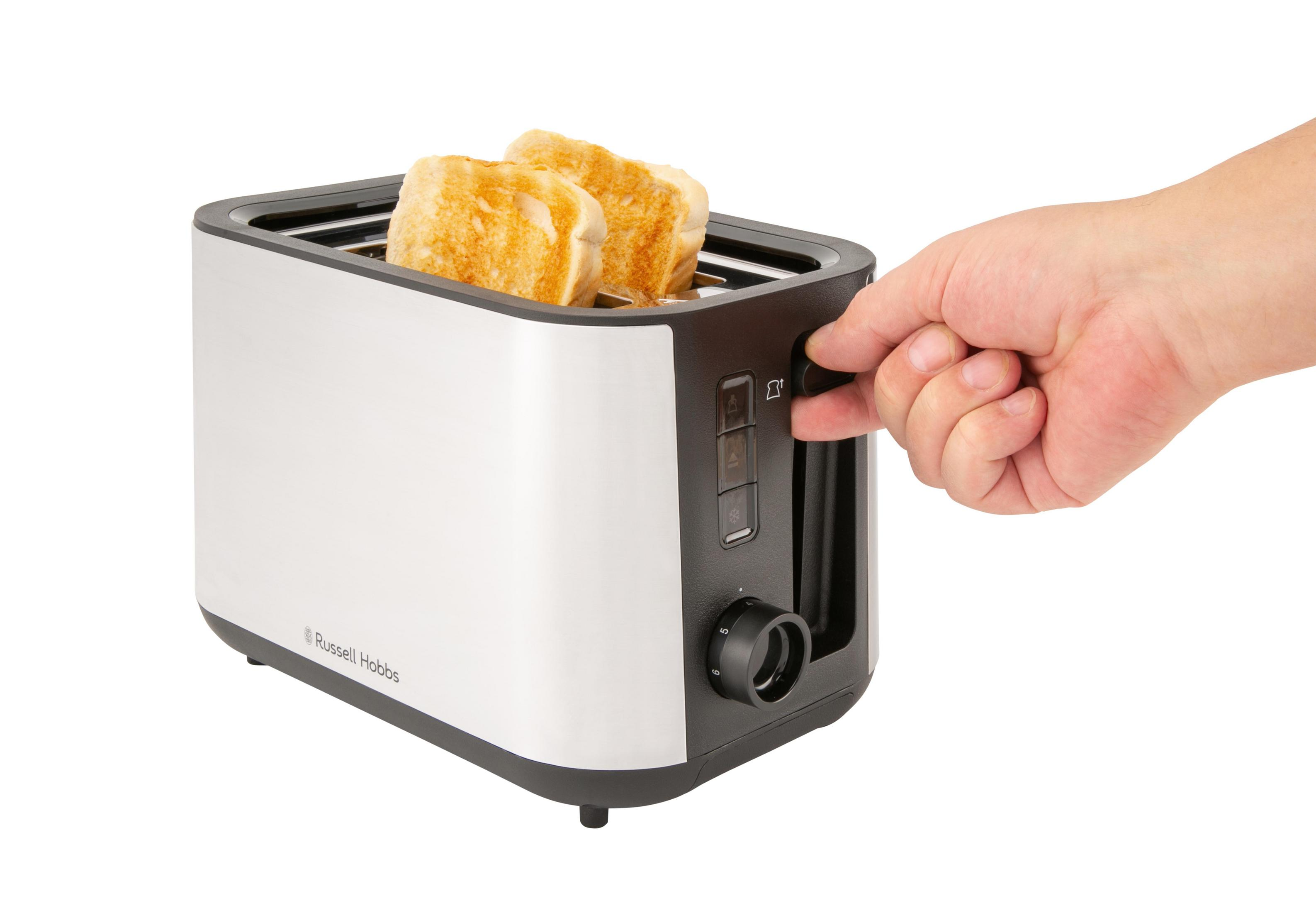 Ein Mensch dreht den Knopf eines Russell Hobbs Toasters mit zwei gerösteten Brotscheiben.