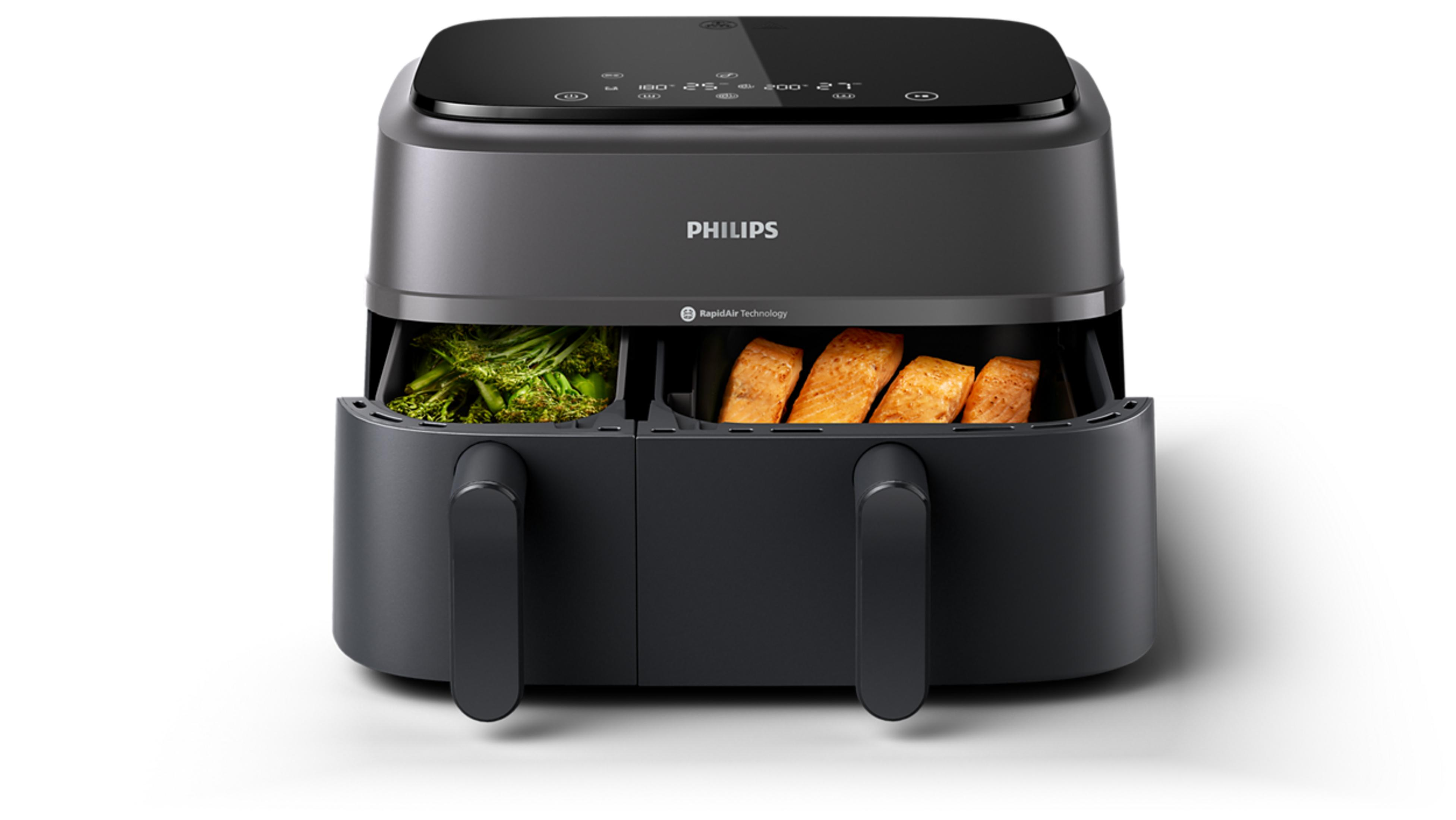Friggitrice ad aria grigio scuro con due cassetti: broccoli a sinistra, salmone a destra.