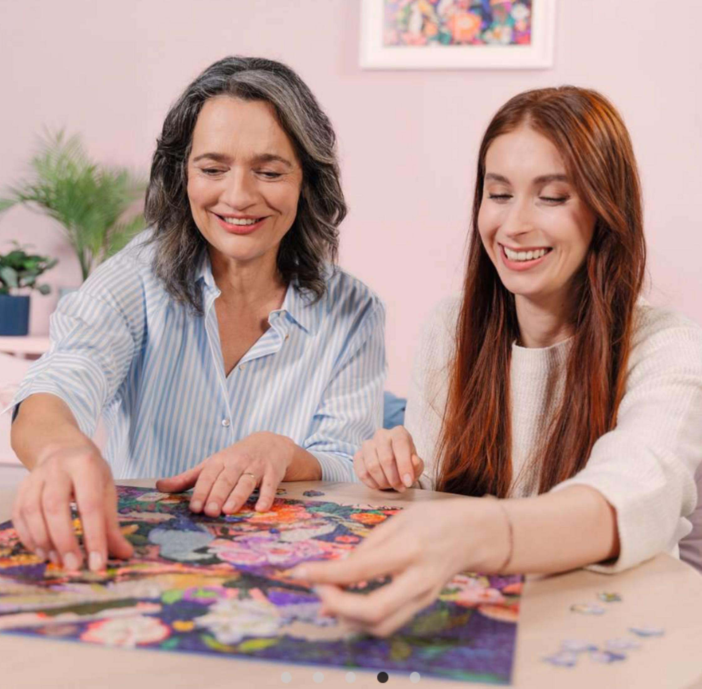 Dos mujeres completan un rompecabezas floral en interiores.