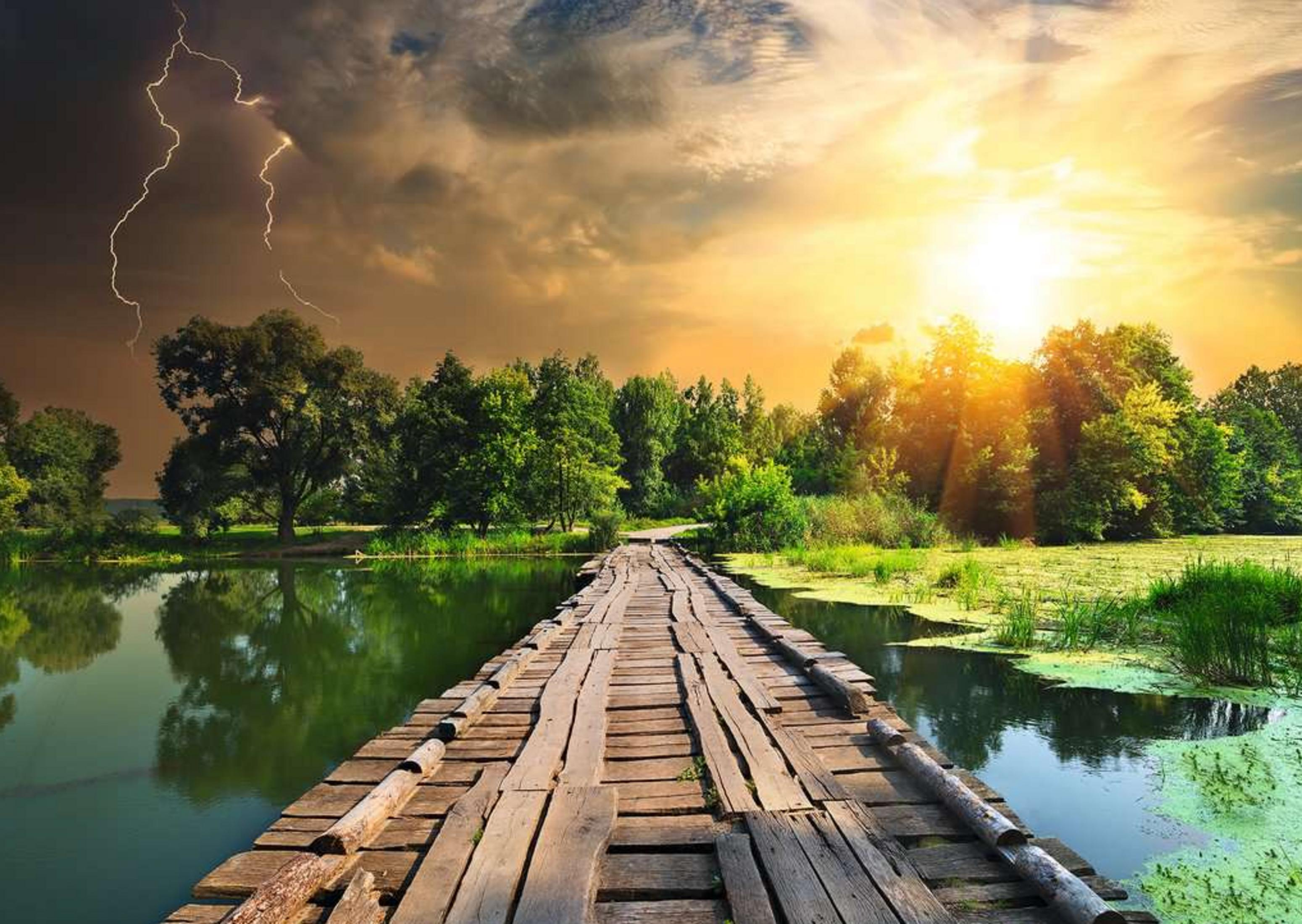 Un pont en bois traverse un étang d'algues vertes, soleil à droite, éclair à gauche.