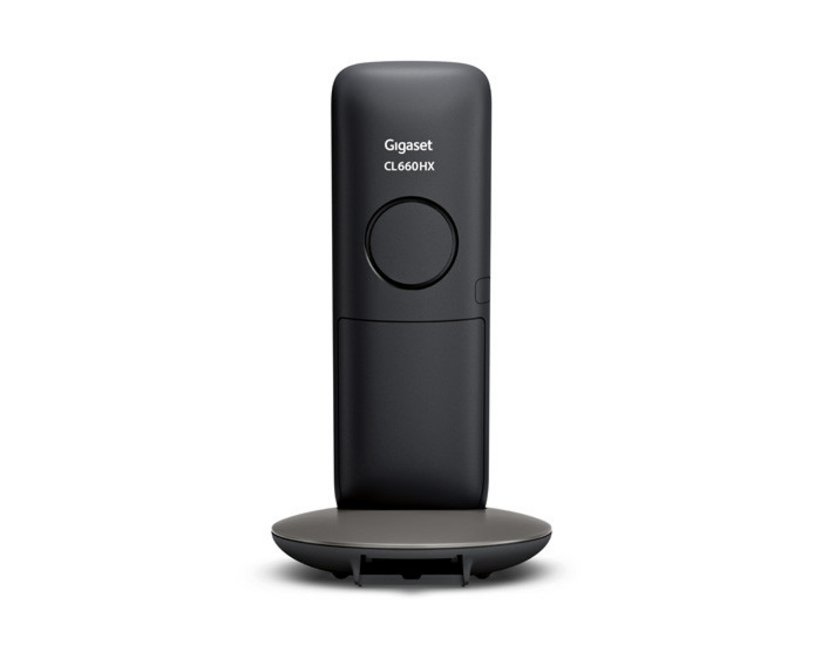 Un telefono cordless nero su una base grigia su sfondo bianco.