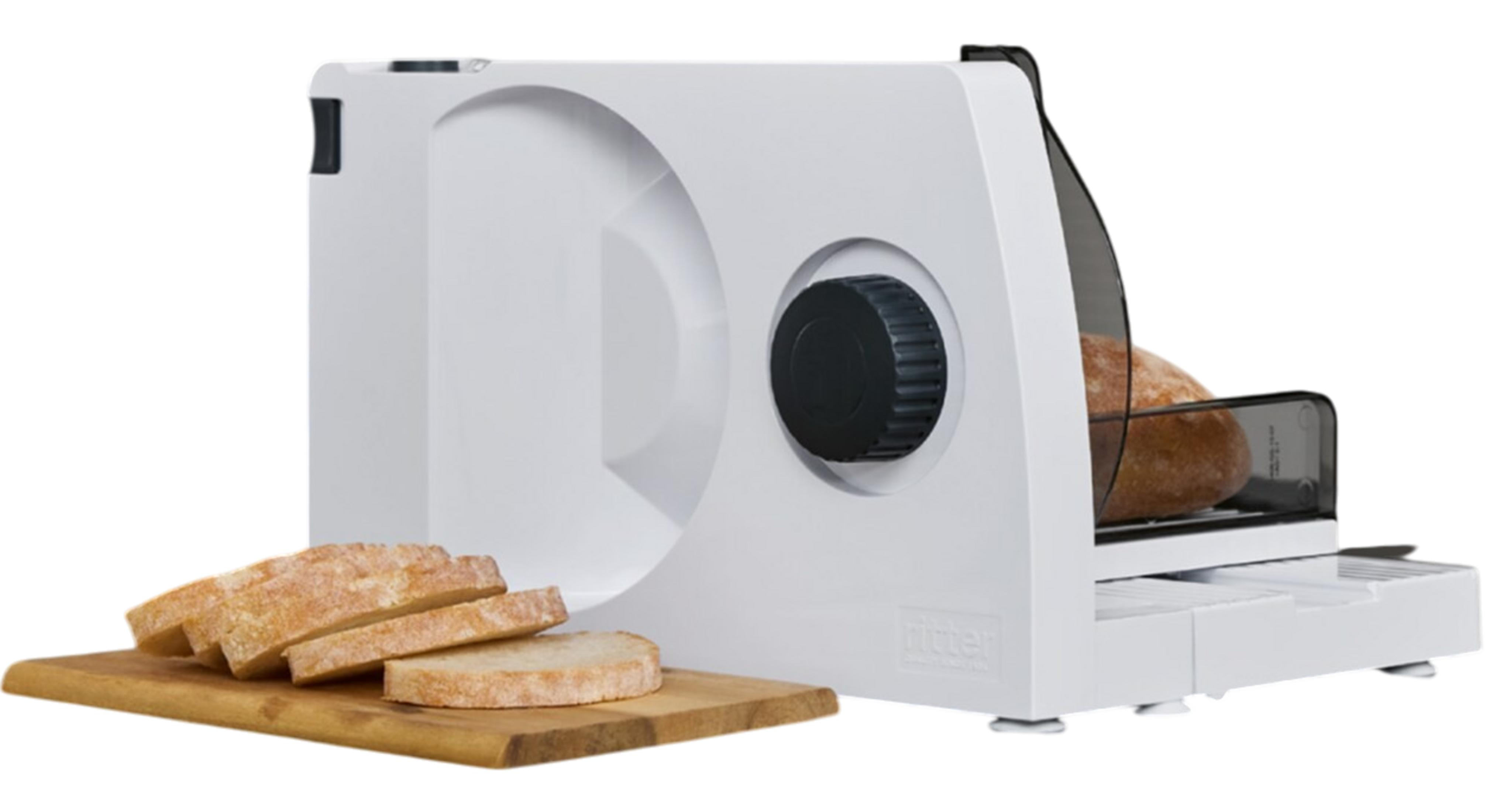 Un'affettatrice per pane bianca con una pagnotta e fette su un tagliere di legno.