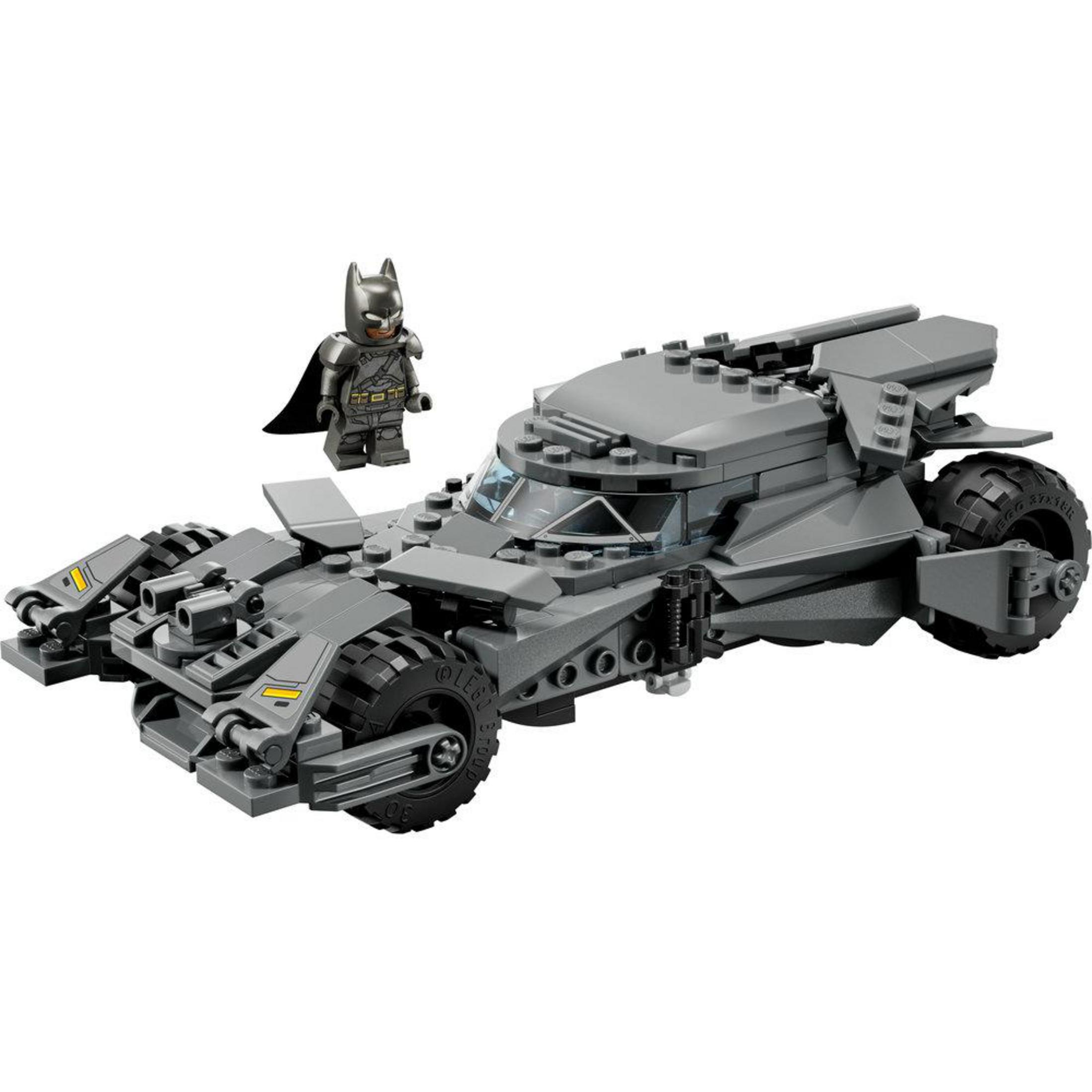 Una minifigure Lego di Batman grigia si trova accanto a una Batmobile Lego grigia con ruote grandi.