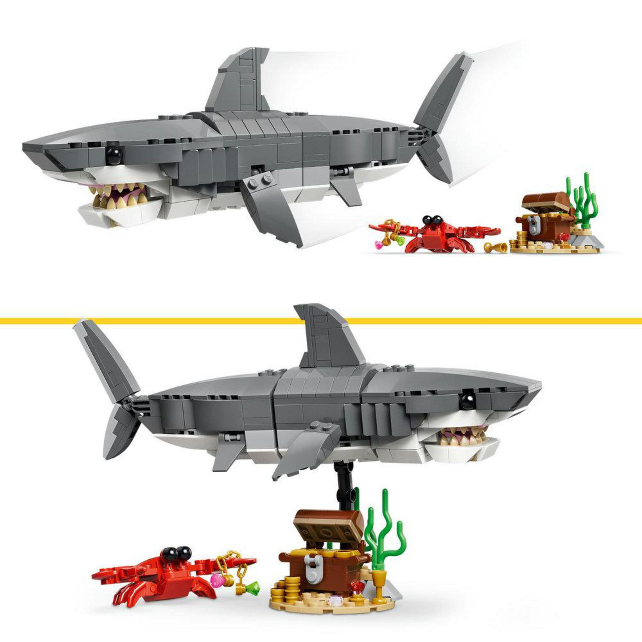 Ağzı açık gri Lego köpekbalığı, kırmızı yengeç, hazine sandığı ve mercan.