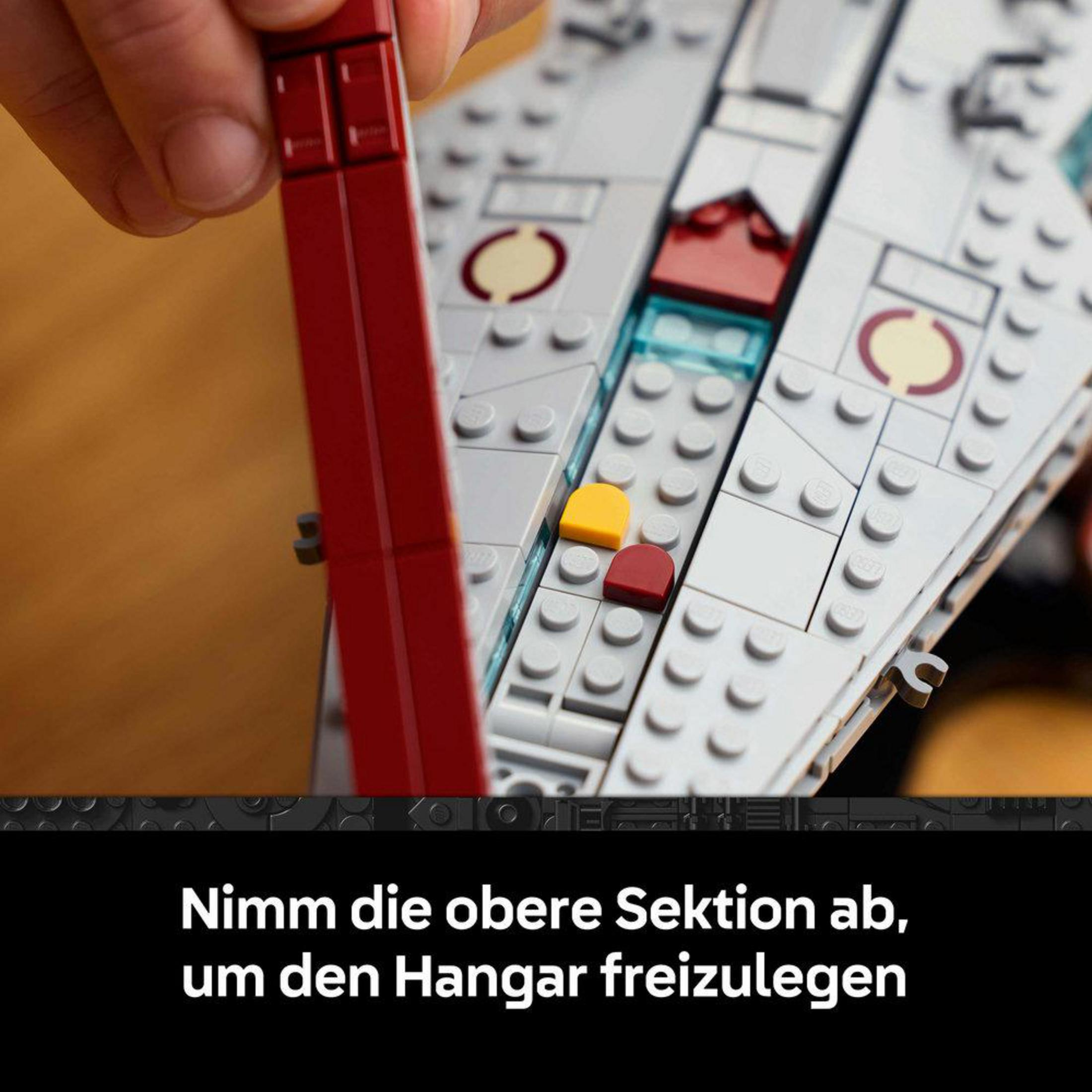 Osoba buduje szary statek kosmiczny Lego z czerwonymi i żółtymi akcentami.