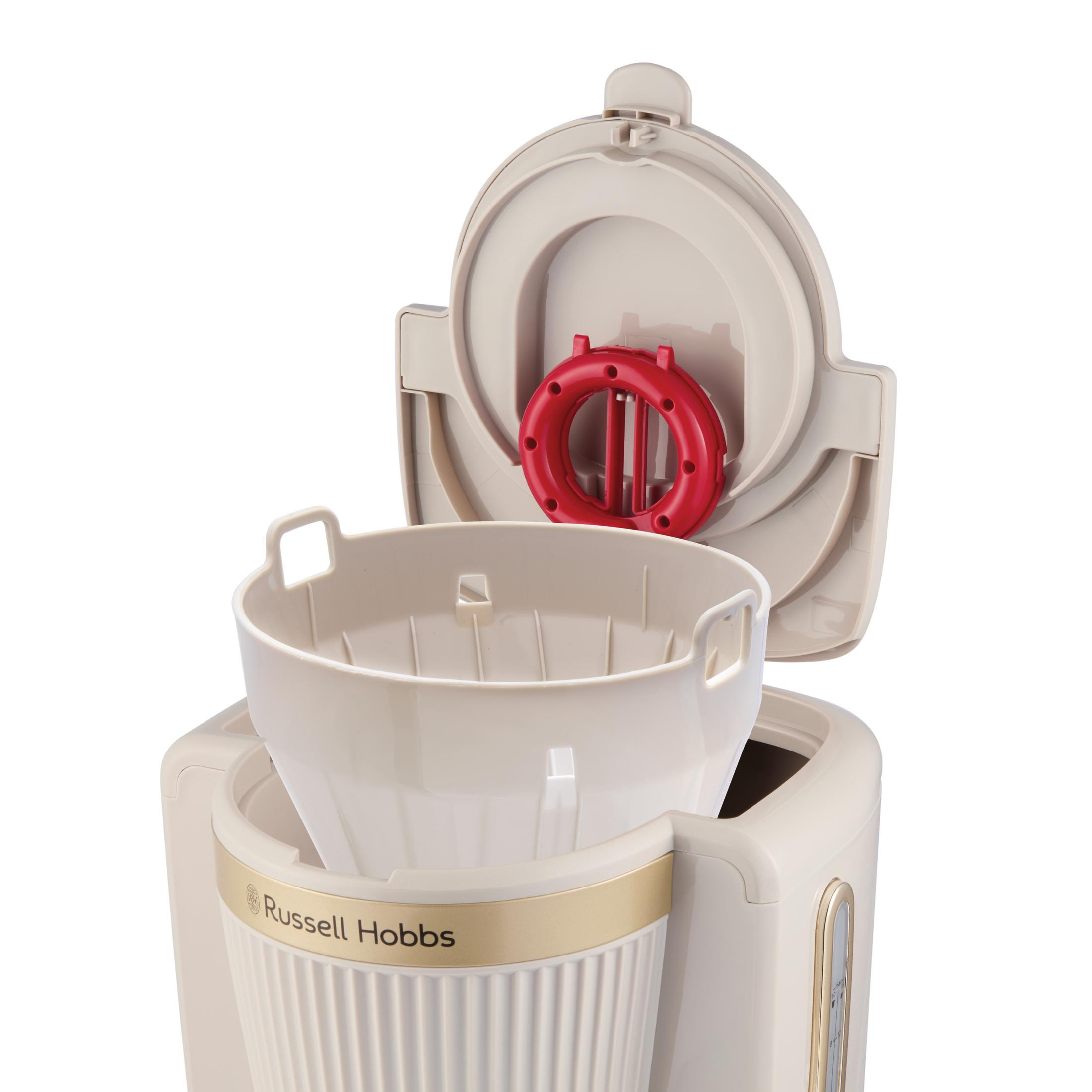 Caffettiera beige con coperchio aperto. Portafiltro rosso visibile.