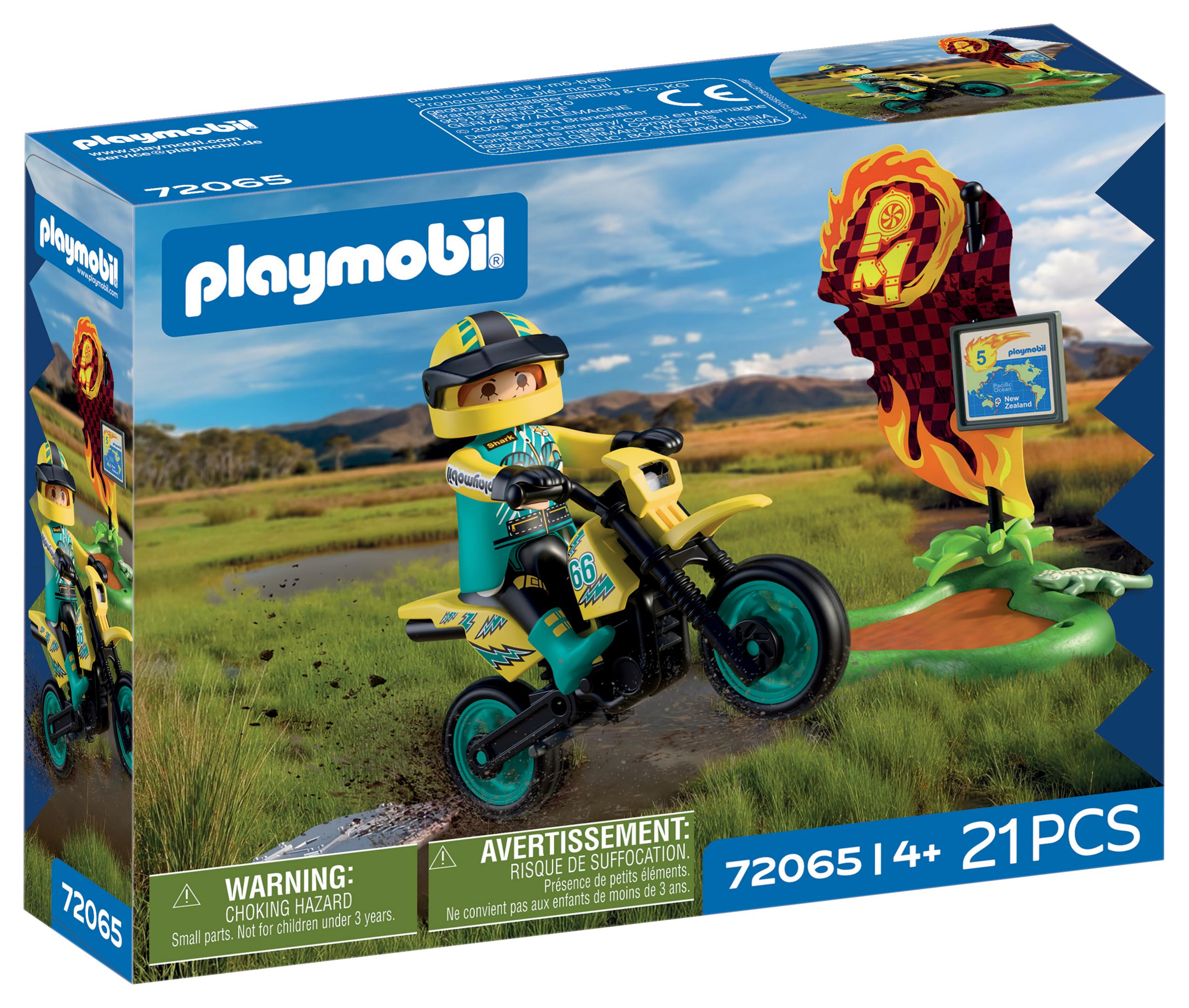 Un piloto de Playmobil verde y amarillo conduce una moto por el barro. Bandera de llamas al lado.