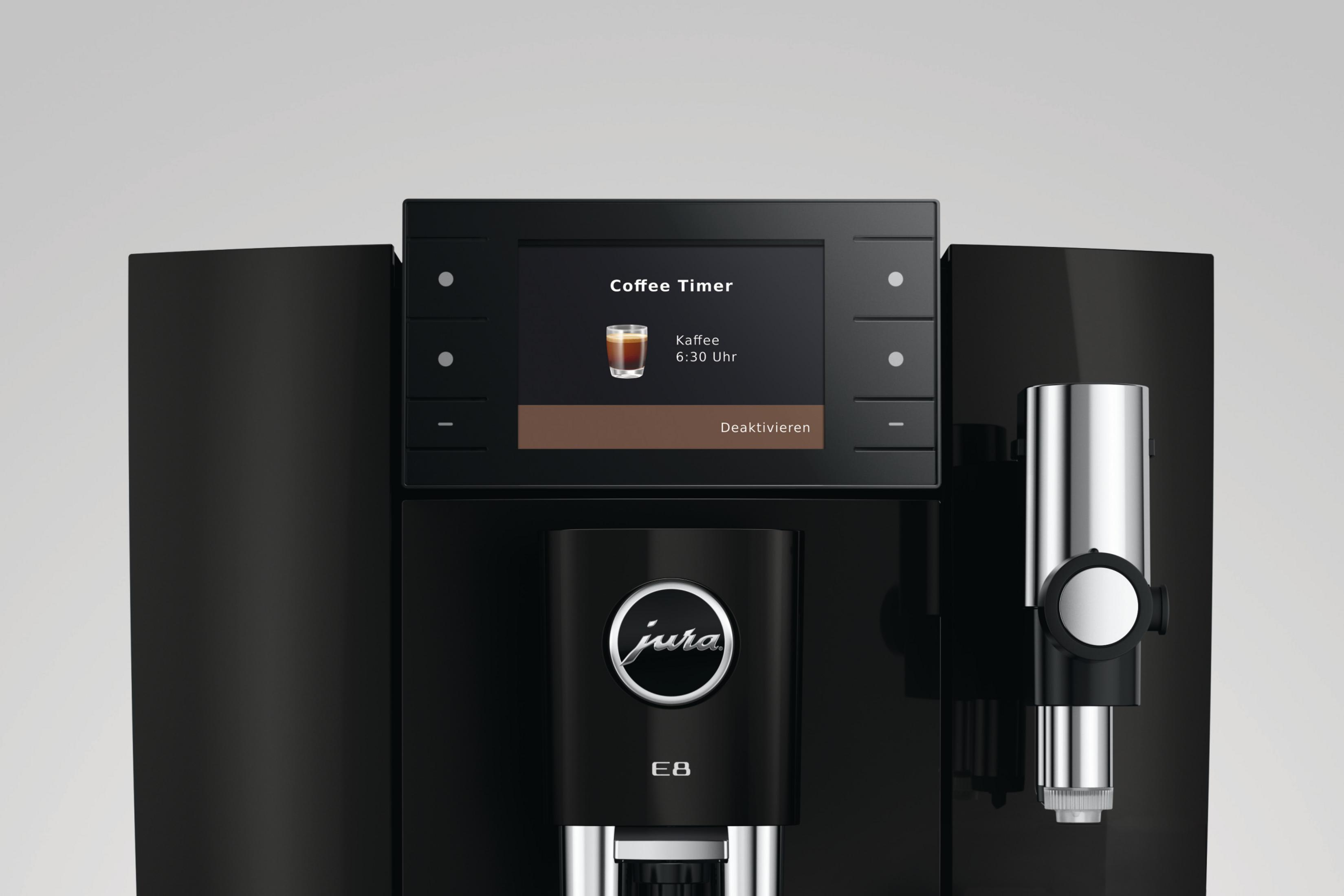 Una macchina da caffè Jura nera con touchscreen che mostra un caffè.
