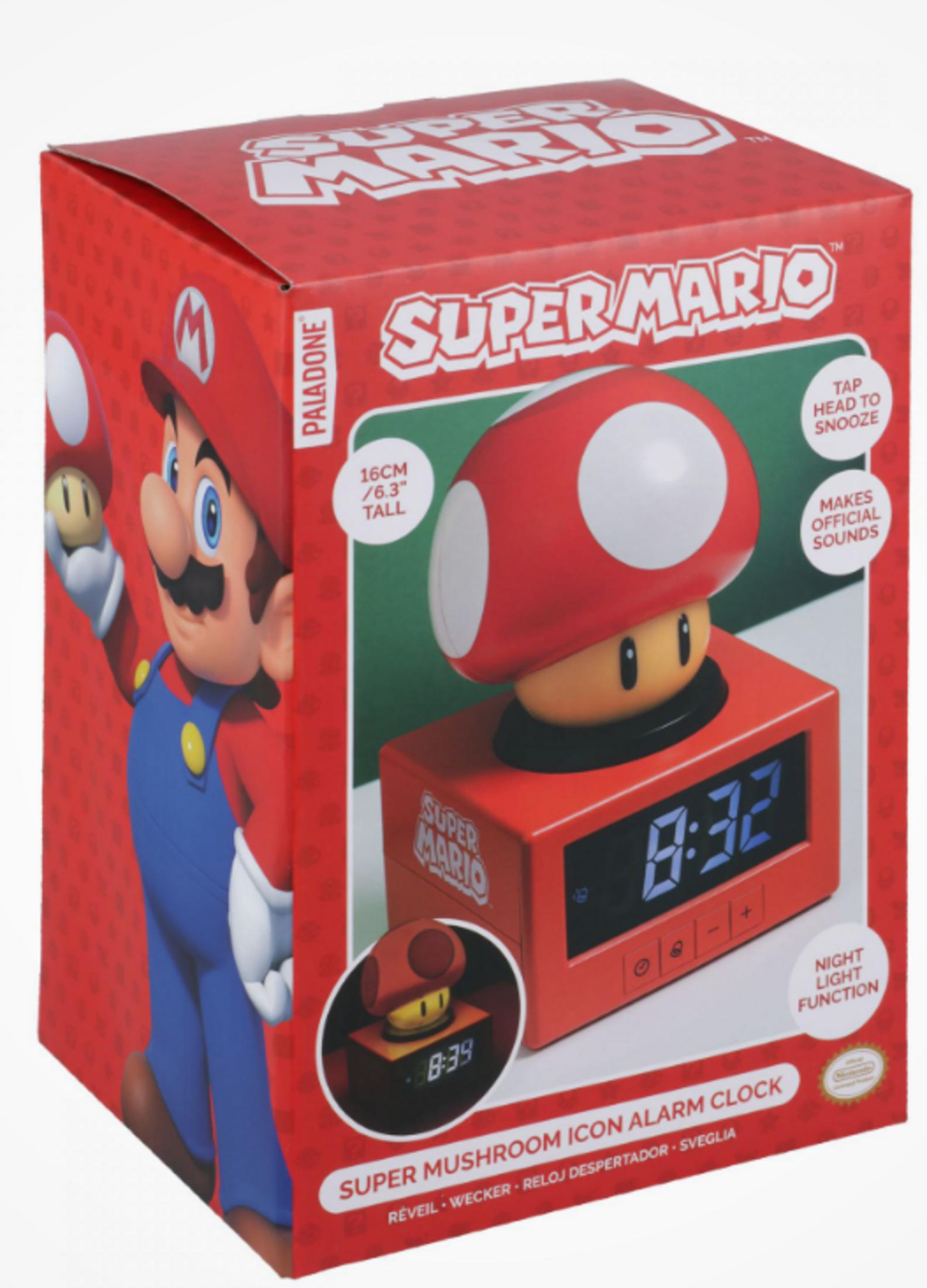 Budzik Super Mario w kształcie grzyba na czerwonym pudełku z ilustracją Mario.
