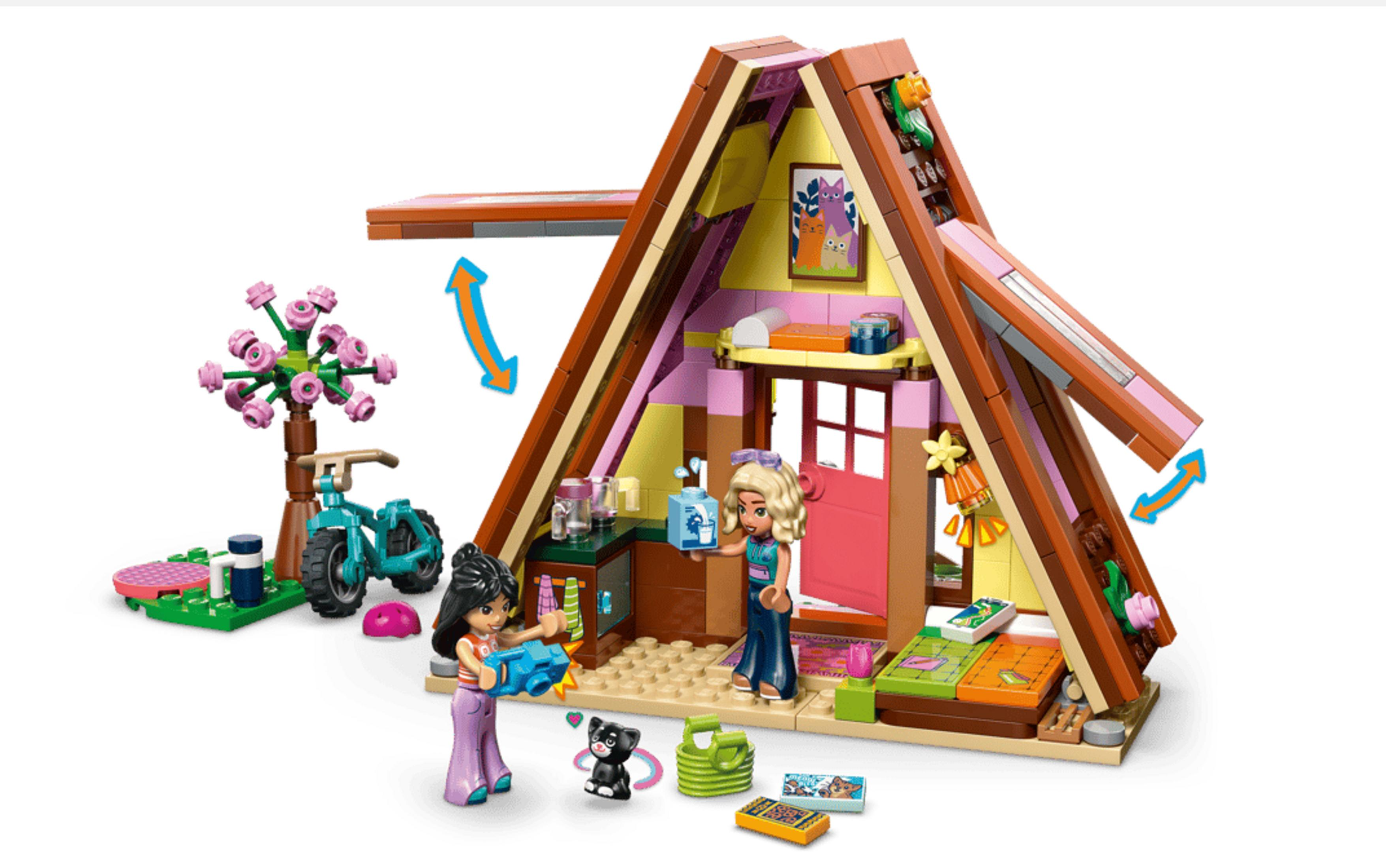 Due bambine giocano con i Lego fuori da una casa giocattolo con albero e bicicletta.