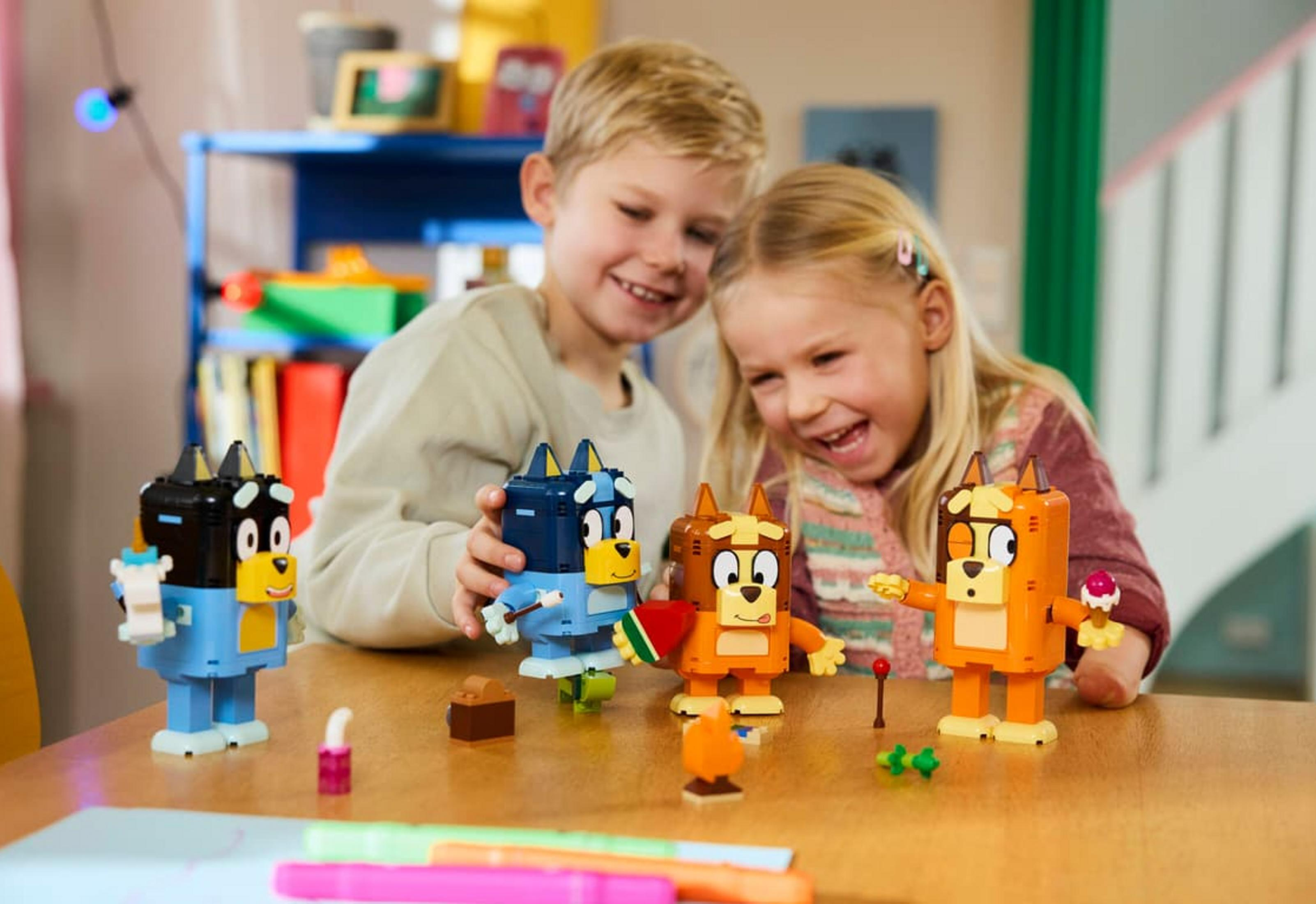 Dos niños construyendo figuras de Lego. Un niño y una niña construyen.