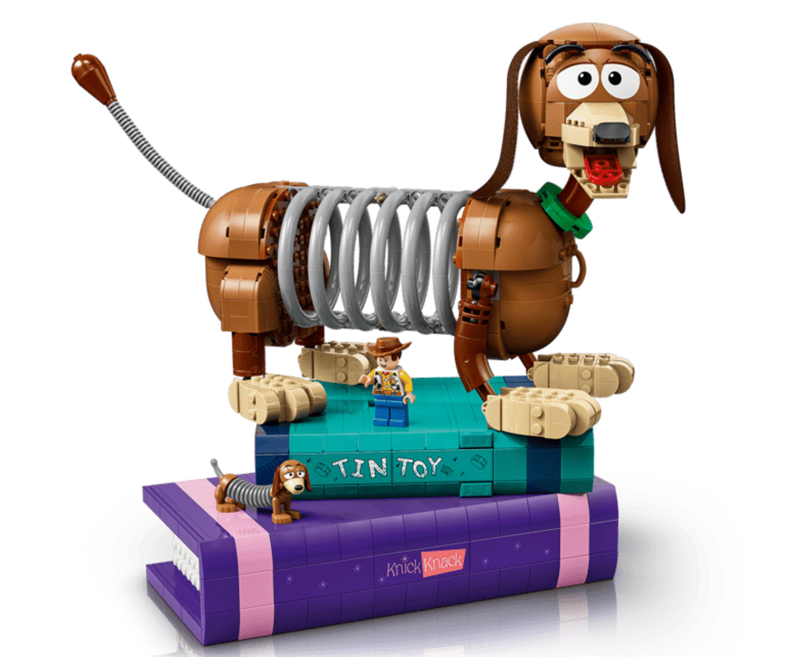 Model LEGO Slinky Dog z Woodym i Slinkym na książkach.