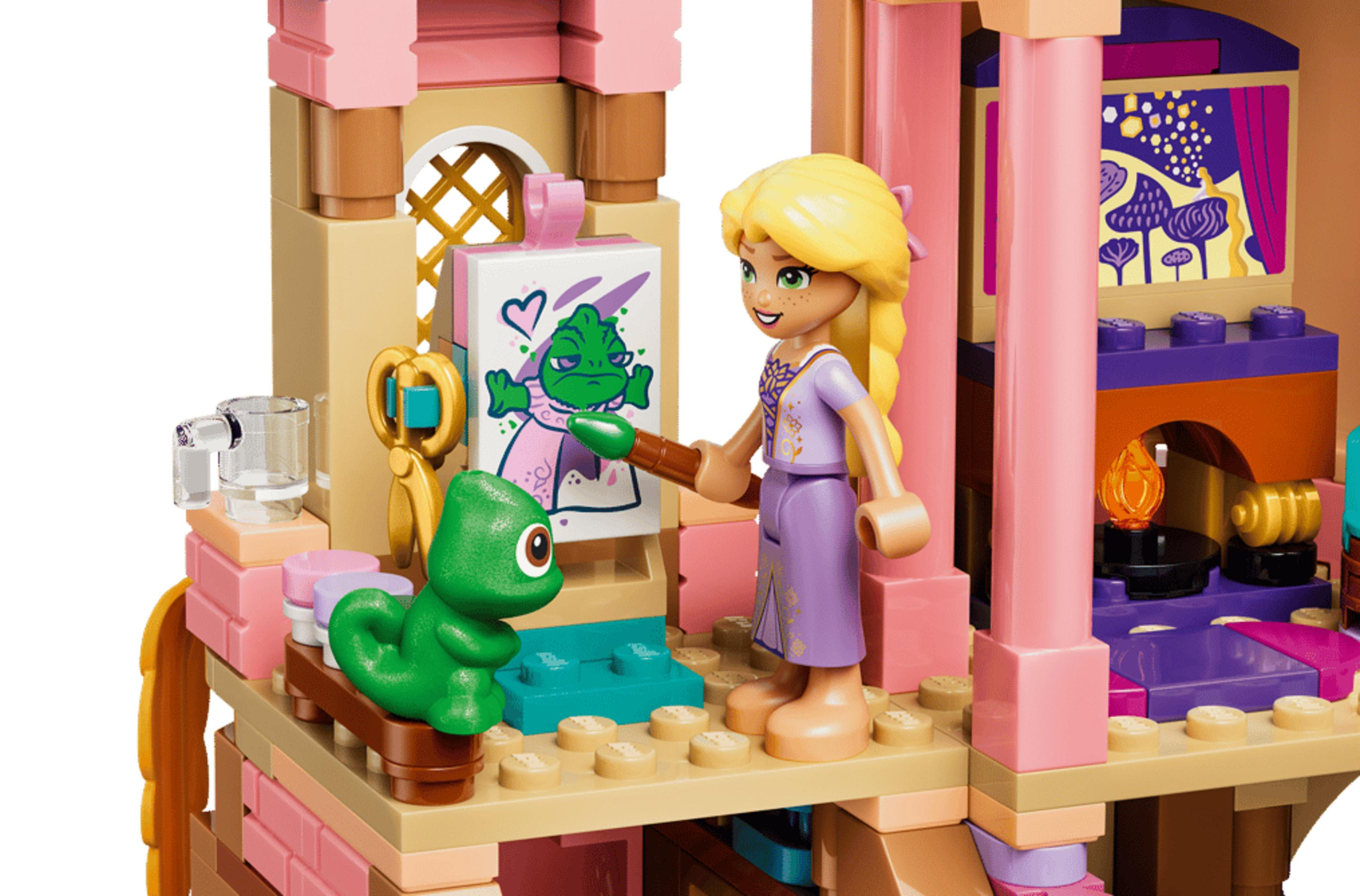 Klocki LEGO przedstawiają Roszpunkę malującą Pascala na płótnie w różowej wieży.