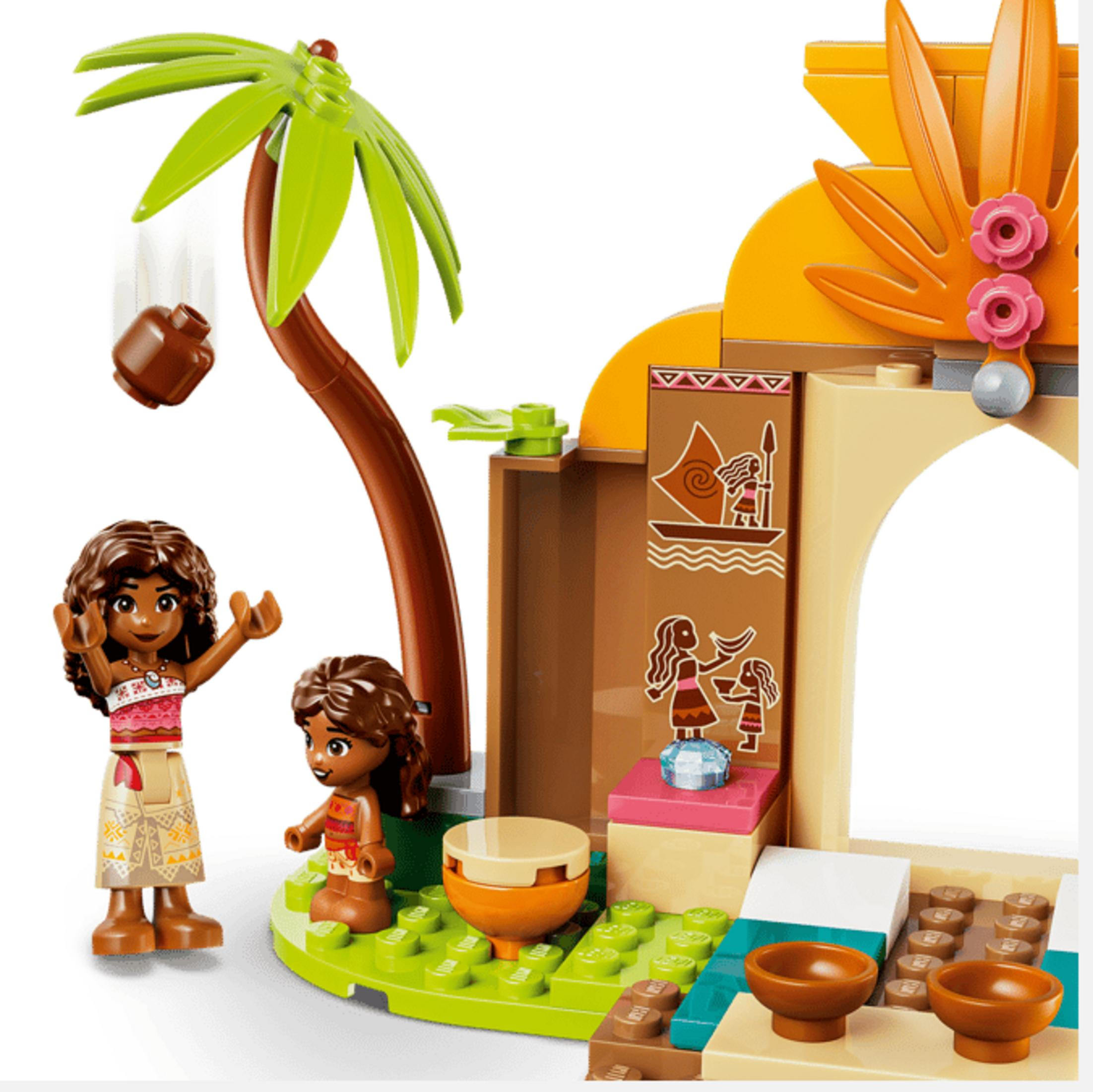 Due figure Lego vicino a una palma e un edificio con decorazioni tropicali.