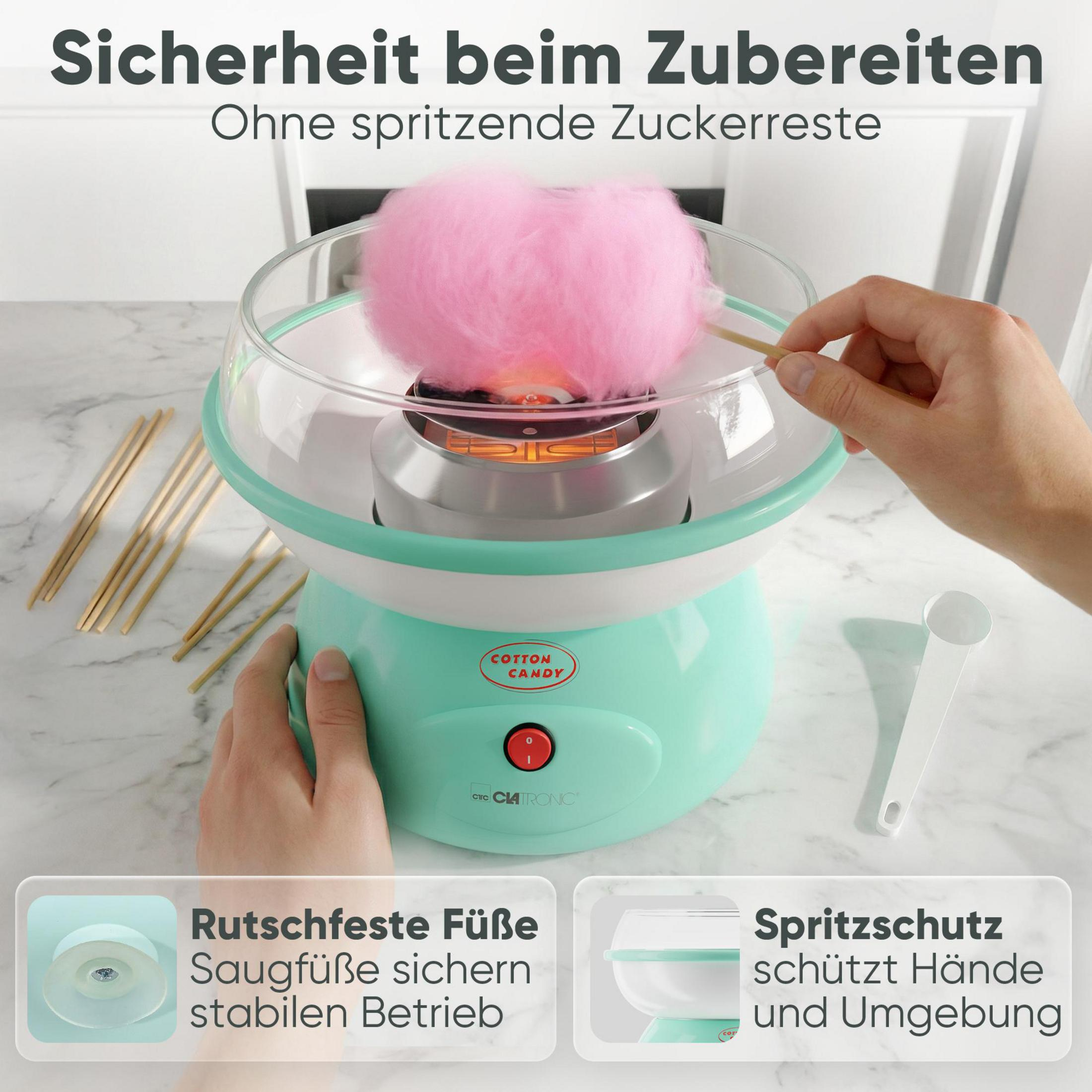 Ein Zuckerwattengerät in Mintgrün mit rosa Zuckerwatte und Holzstäbchen.