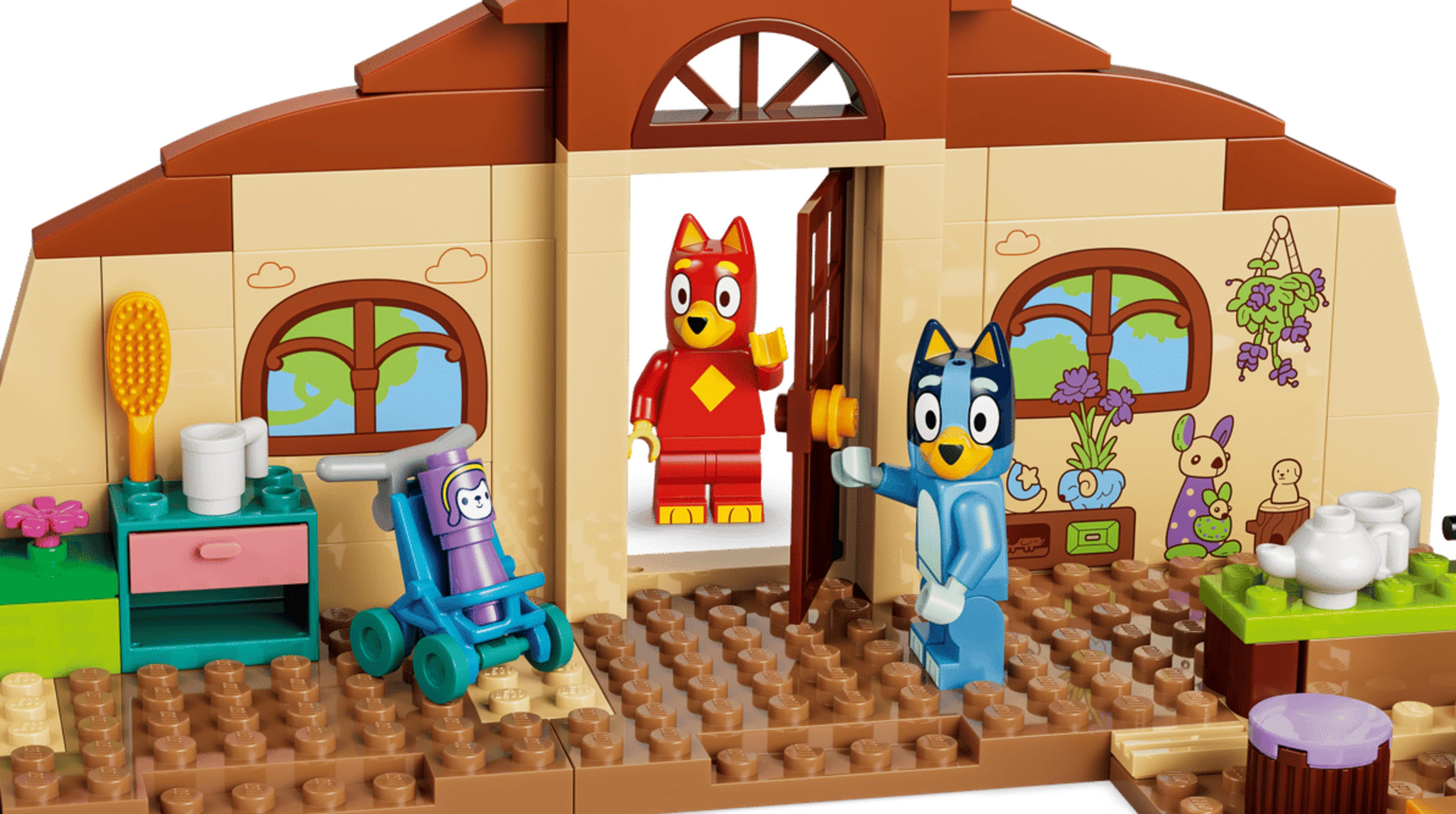 Due figure di cani in una casa Lego, una rossa, una blu. Con mobili e accessori.