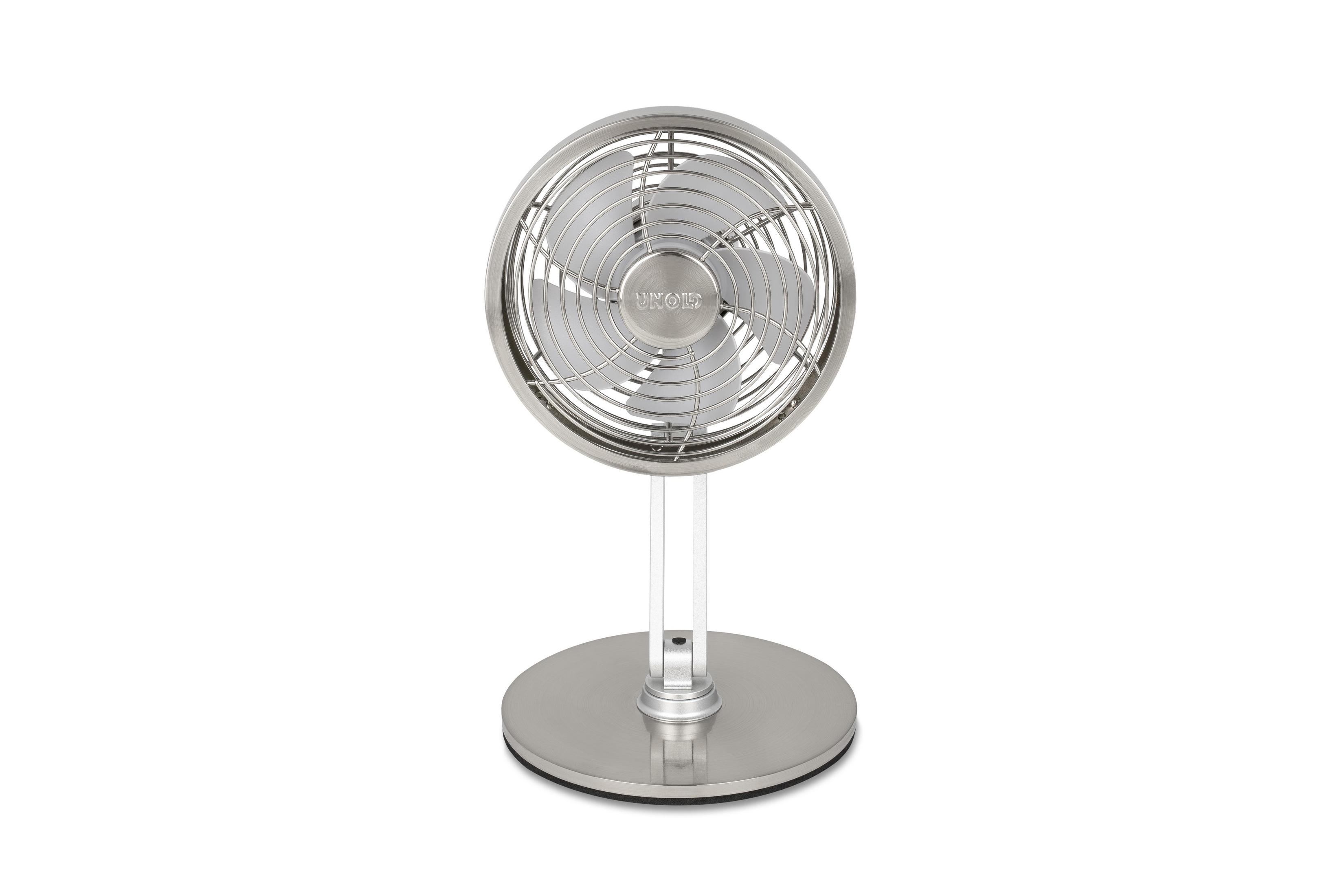 Un ventilatore da tavolo argentato con griglia e base rotonde è mostrato su sfondo bianco.