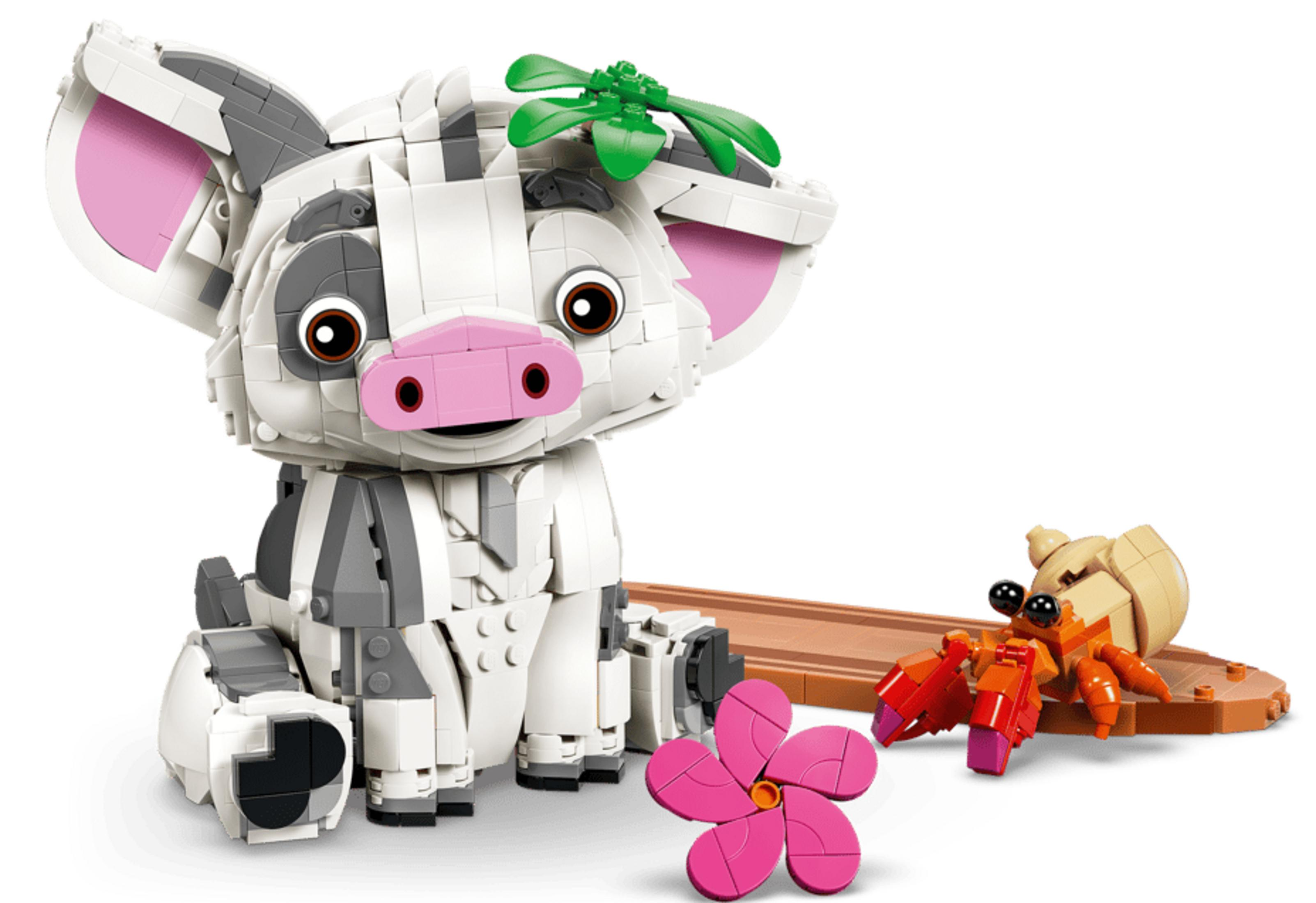 Świnia Lego z zielonymi liśćmi i krab Lego na brązowej podstawie.