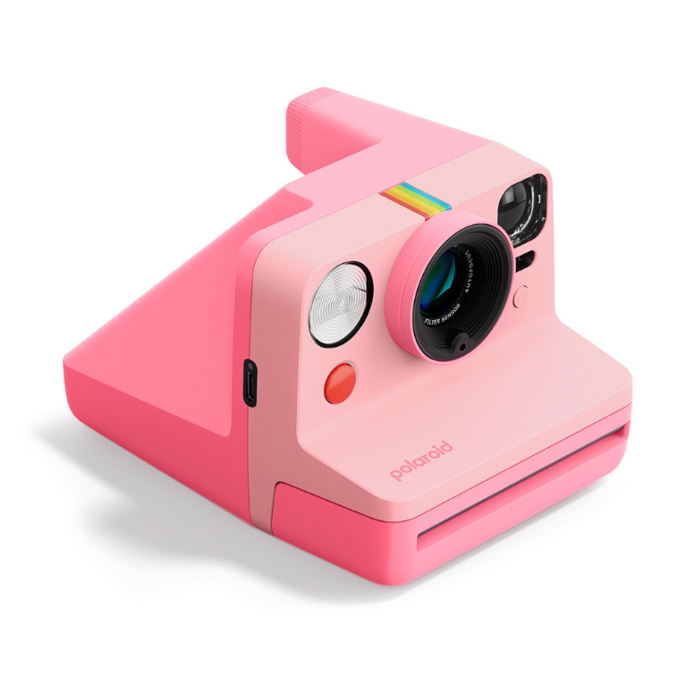 Eine rosafarbene Polaroid-Kamera mit einem Objektiv und einem Blitz.