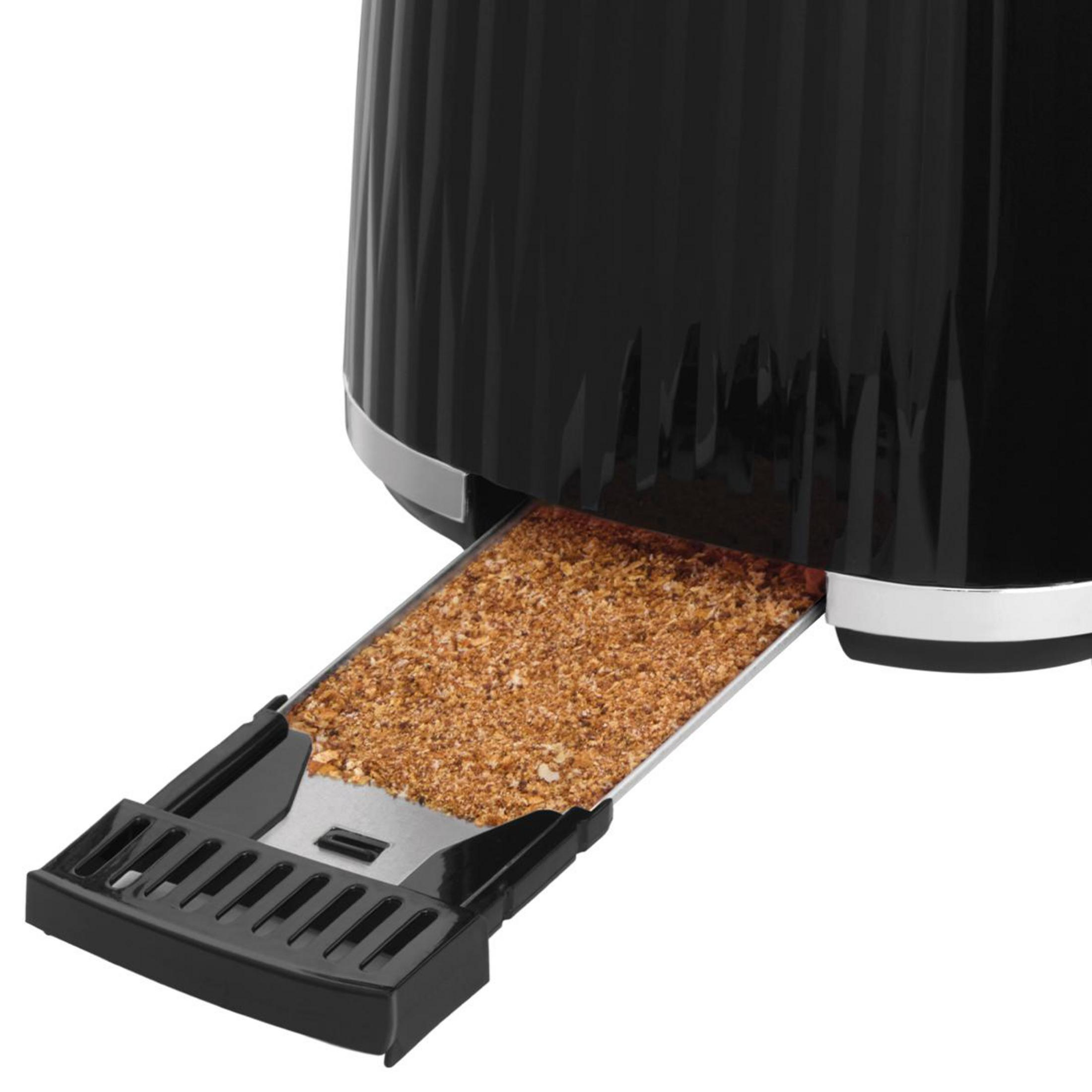 A black toaster with its crumb tray pulled out, filled with toasted crumbs.