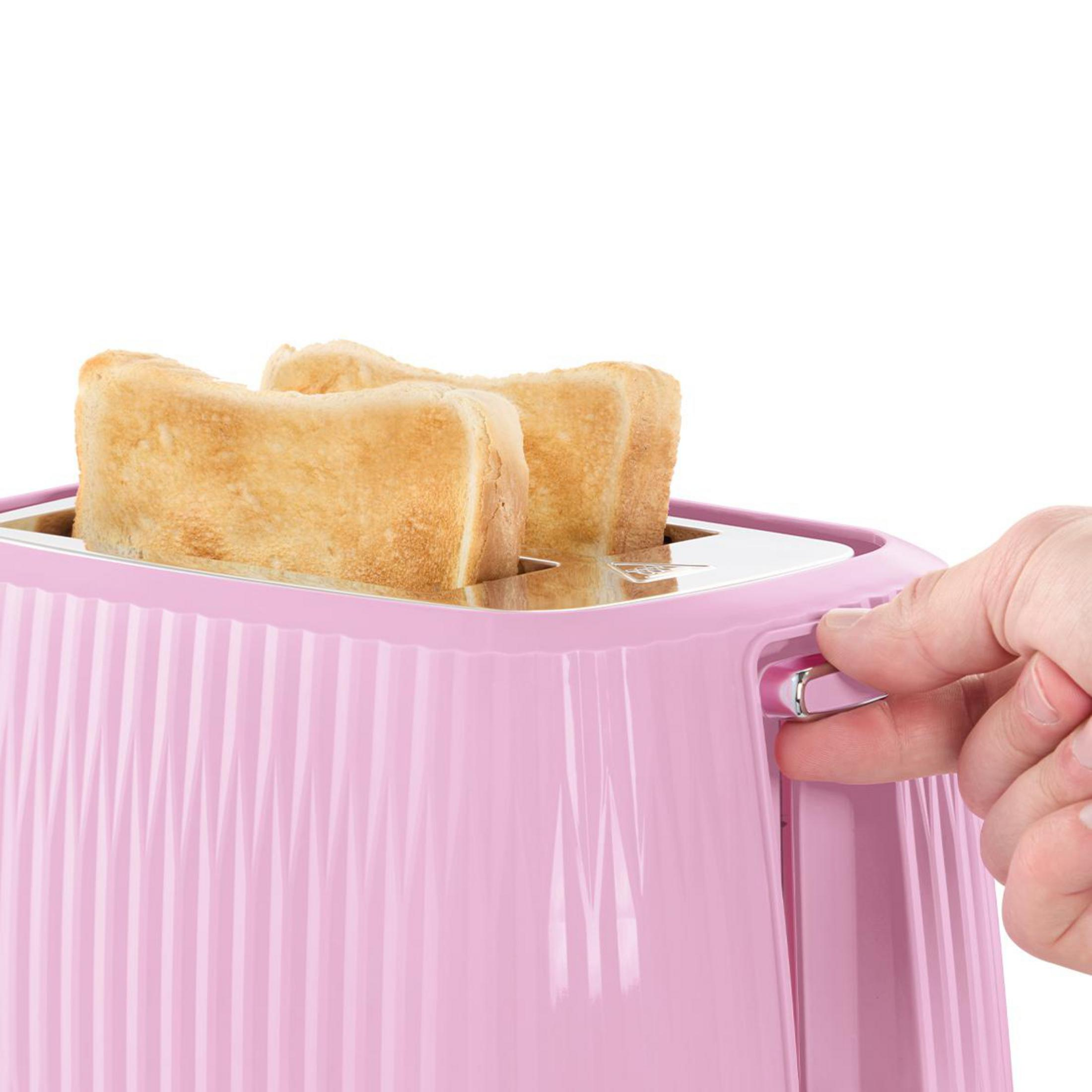 Eine Hand betätigt einen pinken Toaster mit drei Scheiben Toast.