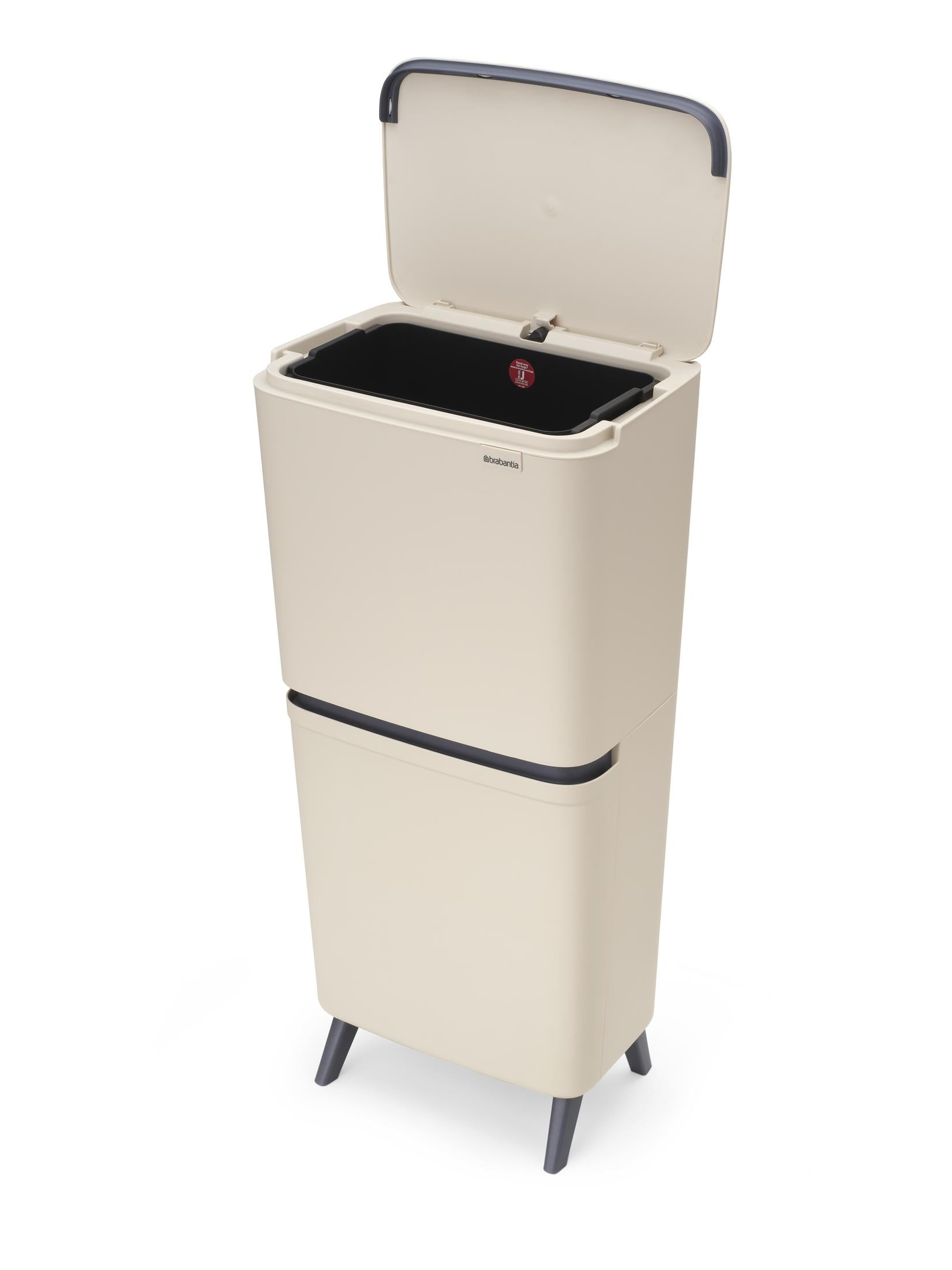 Beige recycling bin with open lid and black inner bucket on legs.