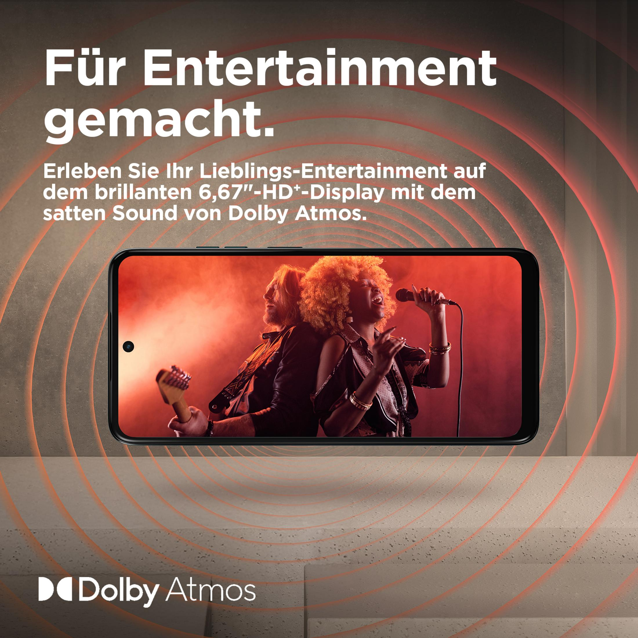 Een smartphone toont twee muzikanten tegen rode rook. Een man met gitaar, een zingende vrouw.