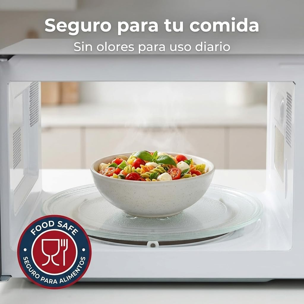 Un tazón humeante de ensalada de pasta con tomates y mozzarella dentro de un microondas blanco.