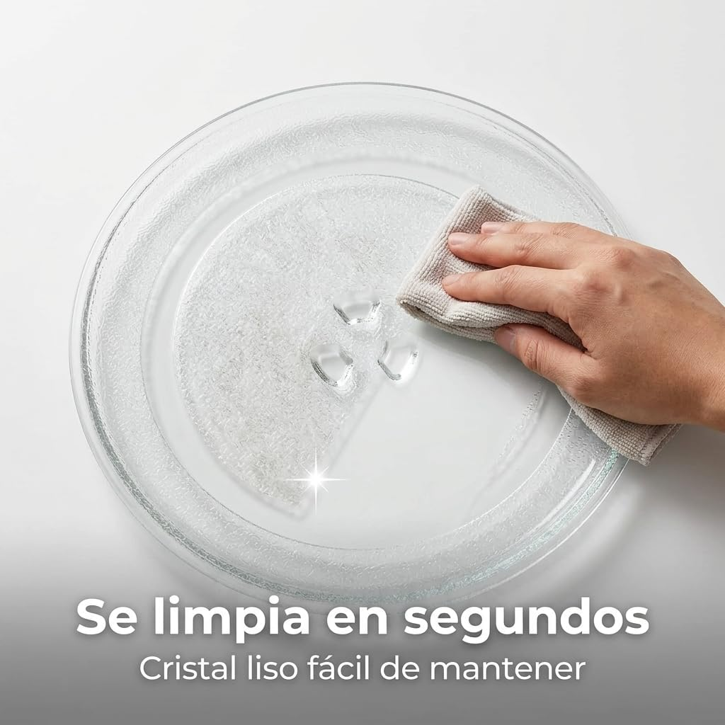 Una mano limpia un plato de cristal con un paño gris. Hay gotas de agua.