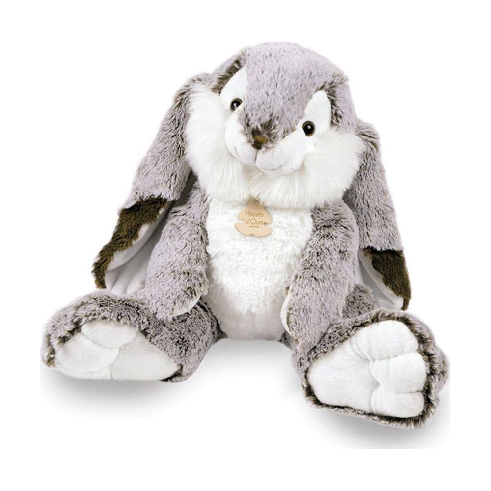 Ein grauer Stoffhase sitzt aufrecht, mit langen Ohren, weißem Bauch und einem Schild.