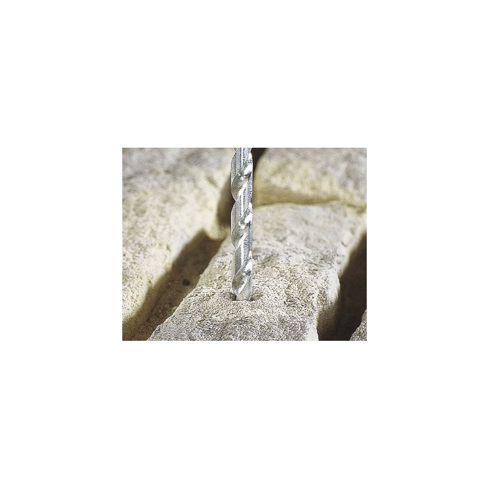 Una broca de metal perfora una piedra beige claro.