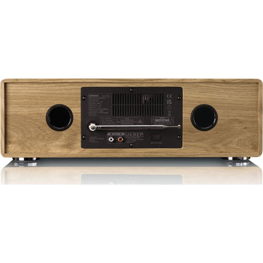 Achterkant van een houten radio met poorten, antenne en luidsprekeropeningen.