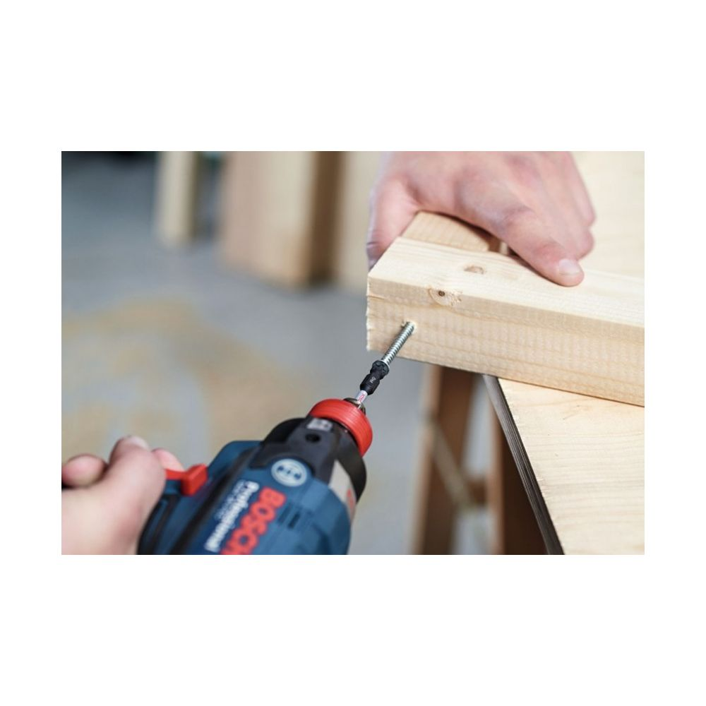 Un avvitatore elettrico inserisce una vite in un pezzo di legno tenuto da una mano.
