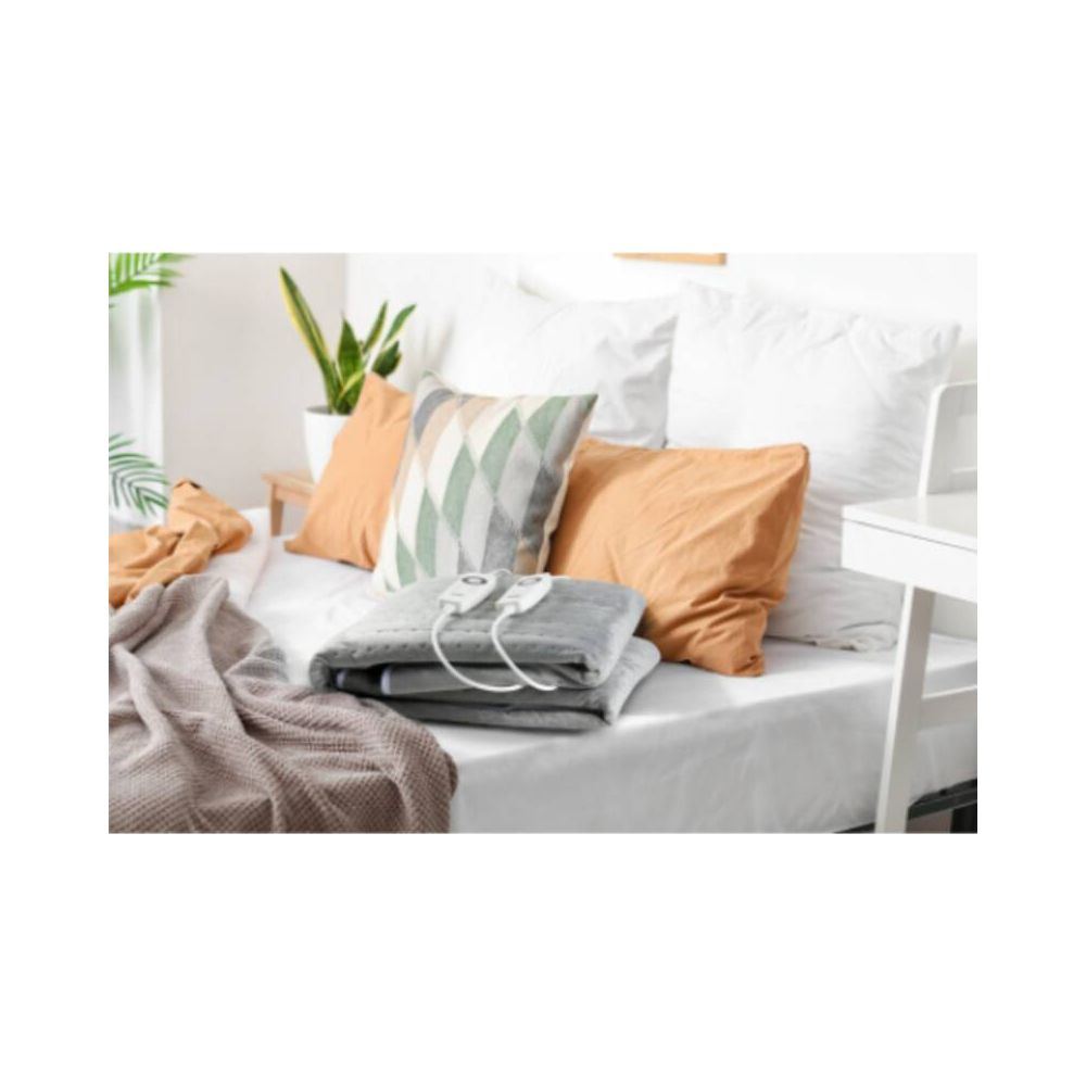 Un termoforo elettrico su un letto con cuscini e coperte.