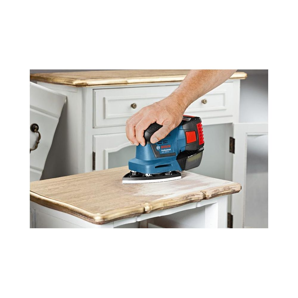 Eine Hand benutzt einen blauen Bosch-Schleifer auf einem Holzmöbel.